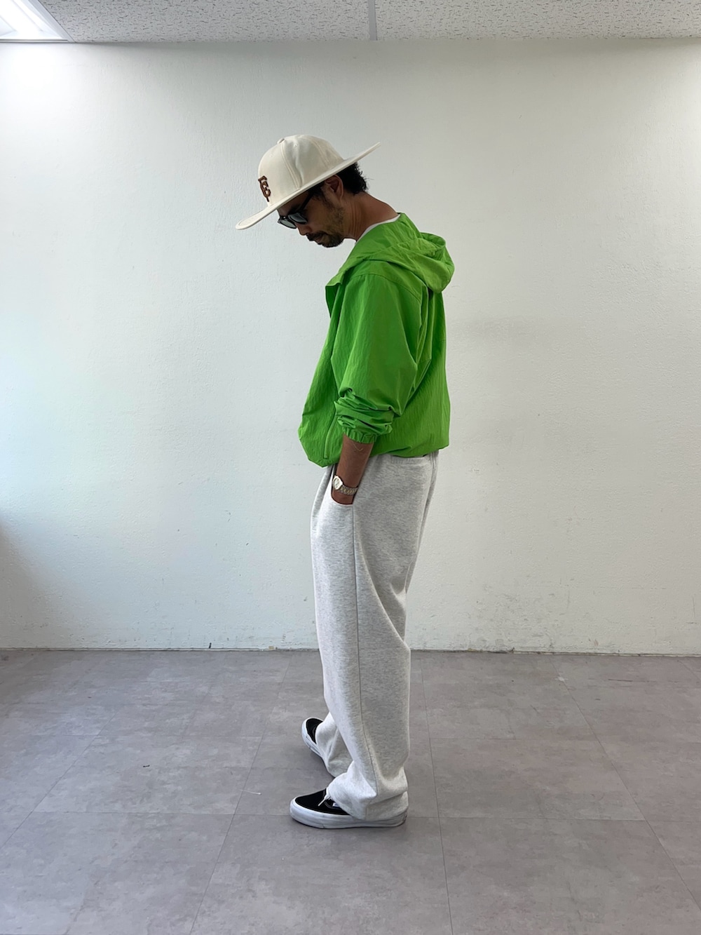 グリーン系のパーカー、ホワイト系のハットを着用したメンズの秋コーディネートの2枚目の写真