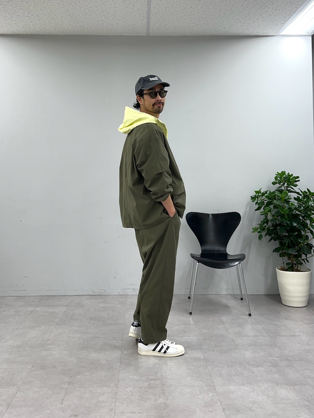 グリーン系のテーラードジャケット、グリーン系のスラックスを着用したメンズの冬コーディネートの2枚目の写真