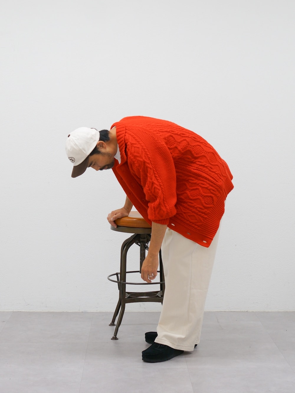 レッド系のカーディガン/ボレロ、ホワイト系のデニムパンツを着用したメンズの冬コーディネートの3枚目の写真