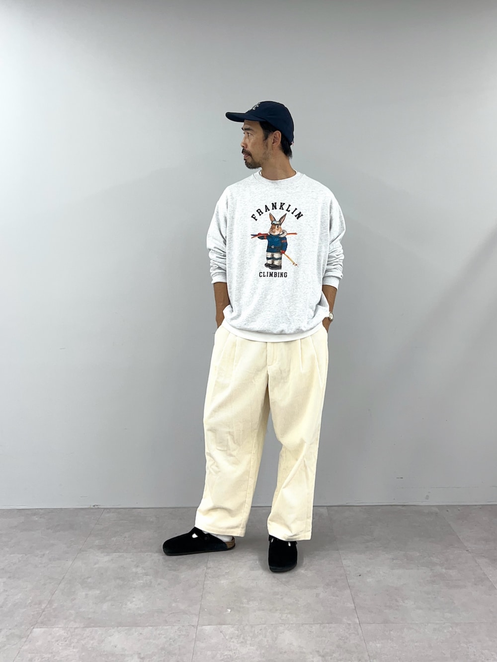 グレー系のスウェット、ホワイト系のパンツを着用したレディースの秋コーディネートの3枚目の写真