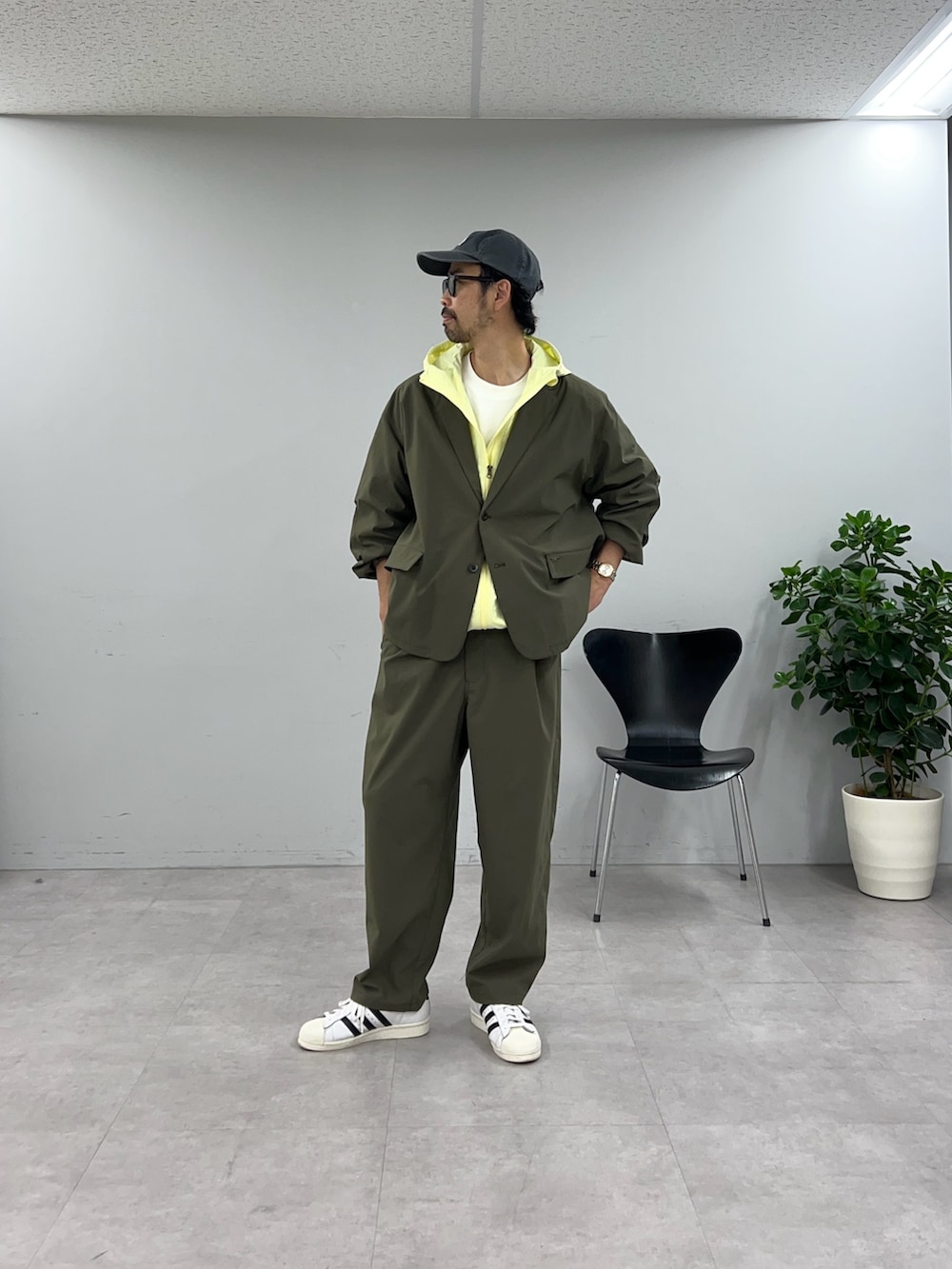 グリーン系のテーラードジャケット、グリーン系のスラックスを着用したメンズの冬コーディネートの3枚目の写真