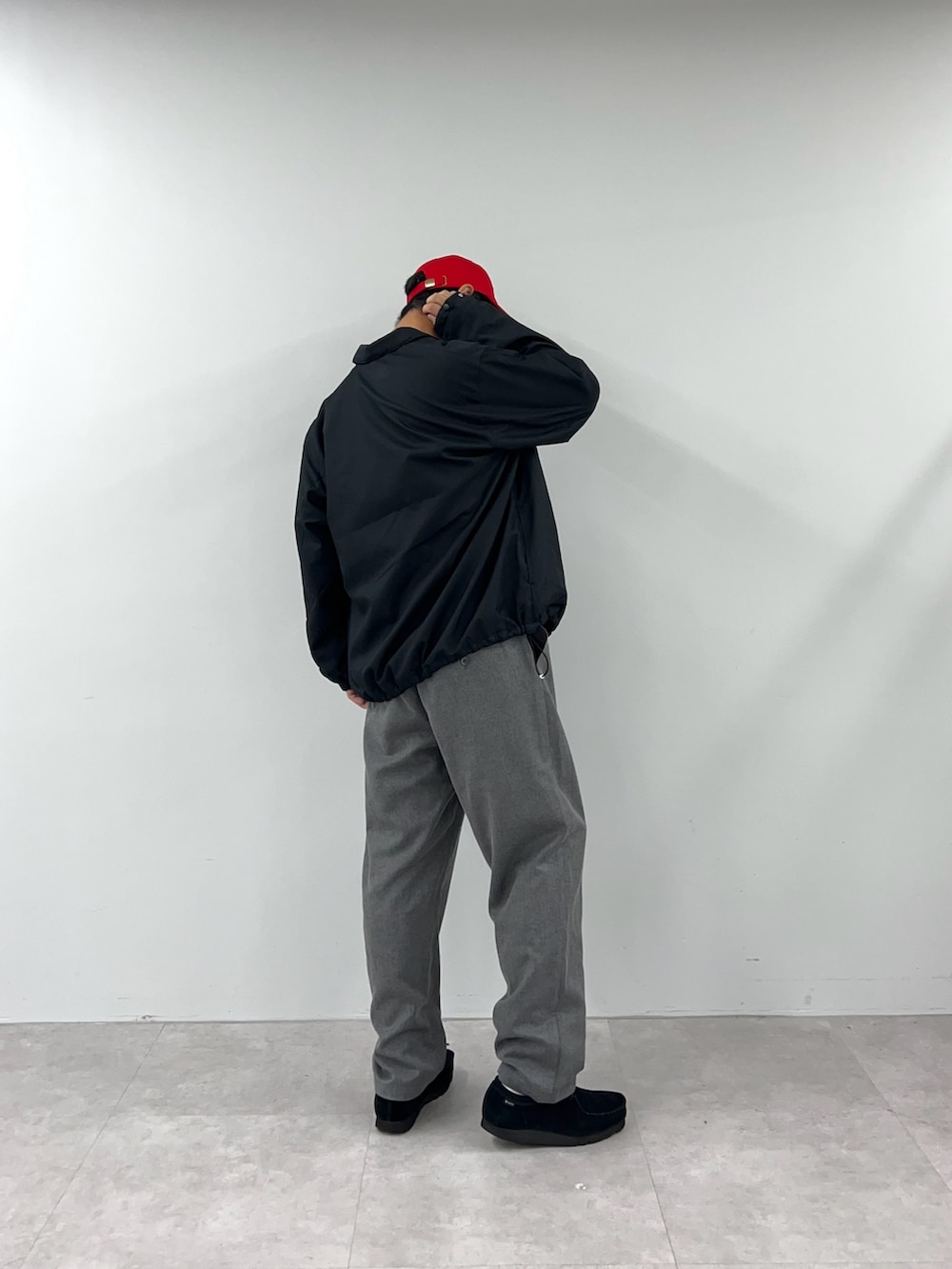 ブラック系のブルゾン、グレー系のチノパンツを着用したメンズの秋コーディネートの4枚目の写真