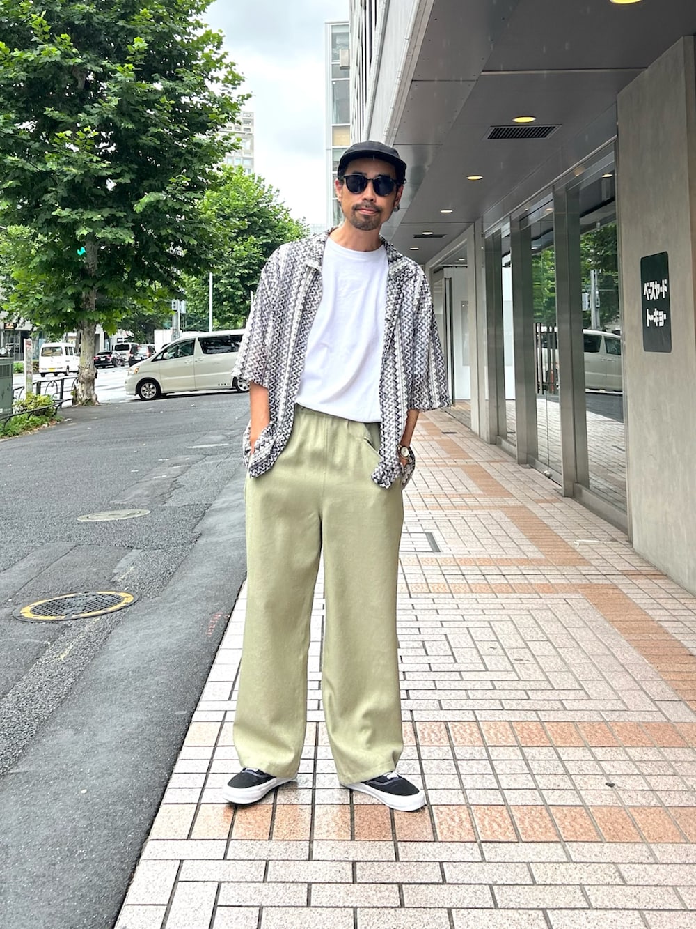 グレー系のシャツ/ブラウス、グリーン系のスラックス、ホワイト系のTシャツ/カットソーを着用したメンズの夏コーディネートの3枚目の写真