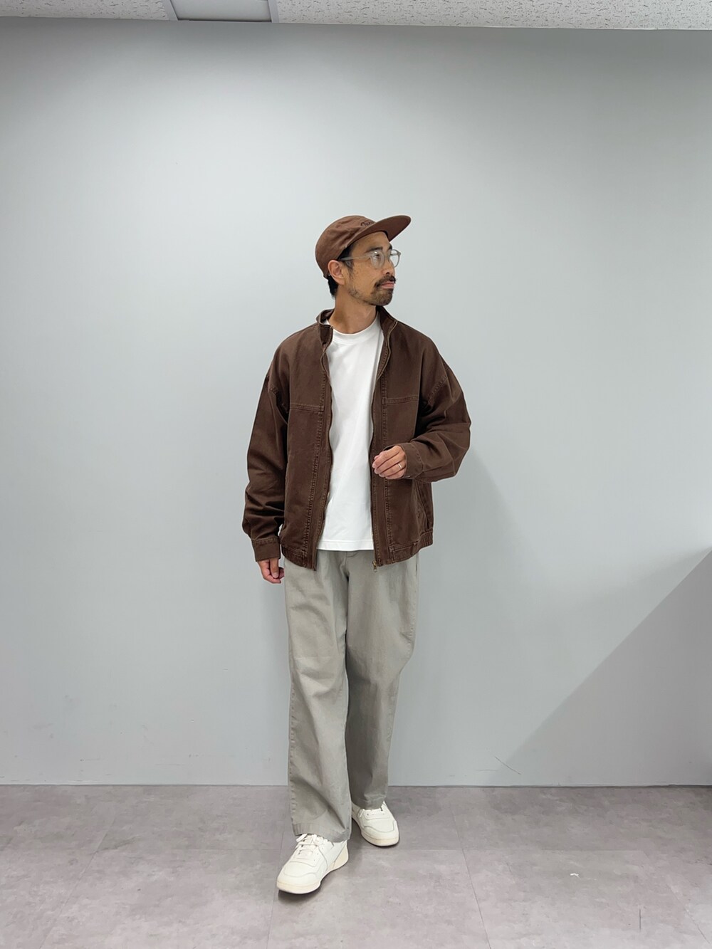 ブラウン系のデニムジャケット、グレー系のその他パンツ、ブラウン系のキャップを着用したメンズの秋コーディネートの2枚目の写真