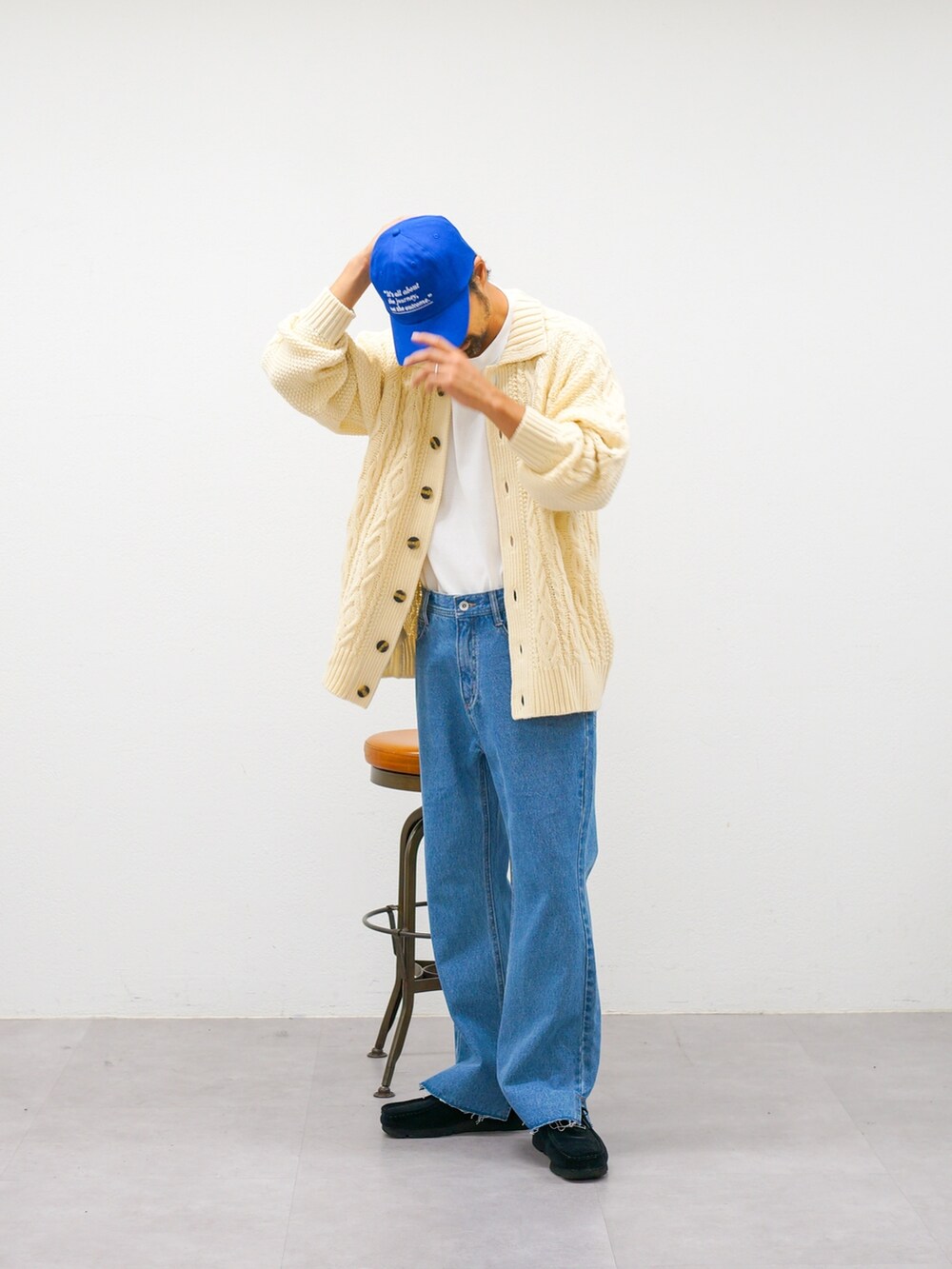 ホワイト系のカーディガン/ボレロ、ブルー系のデニムパンツ、ブルー系のキャップを着用したメンズの秋コーディネートの2枚目の写真