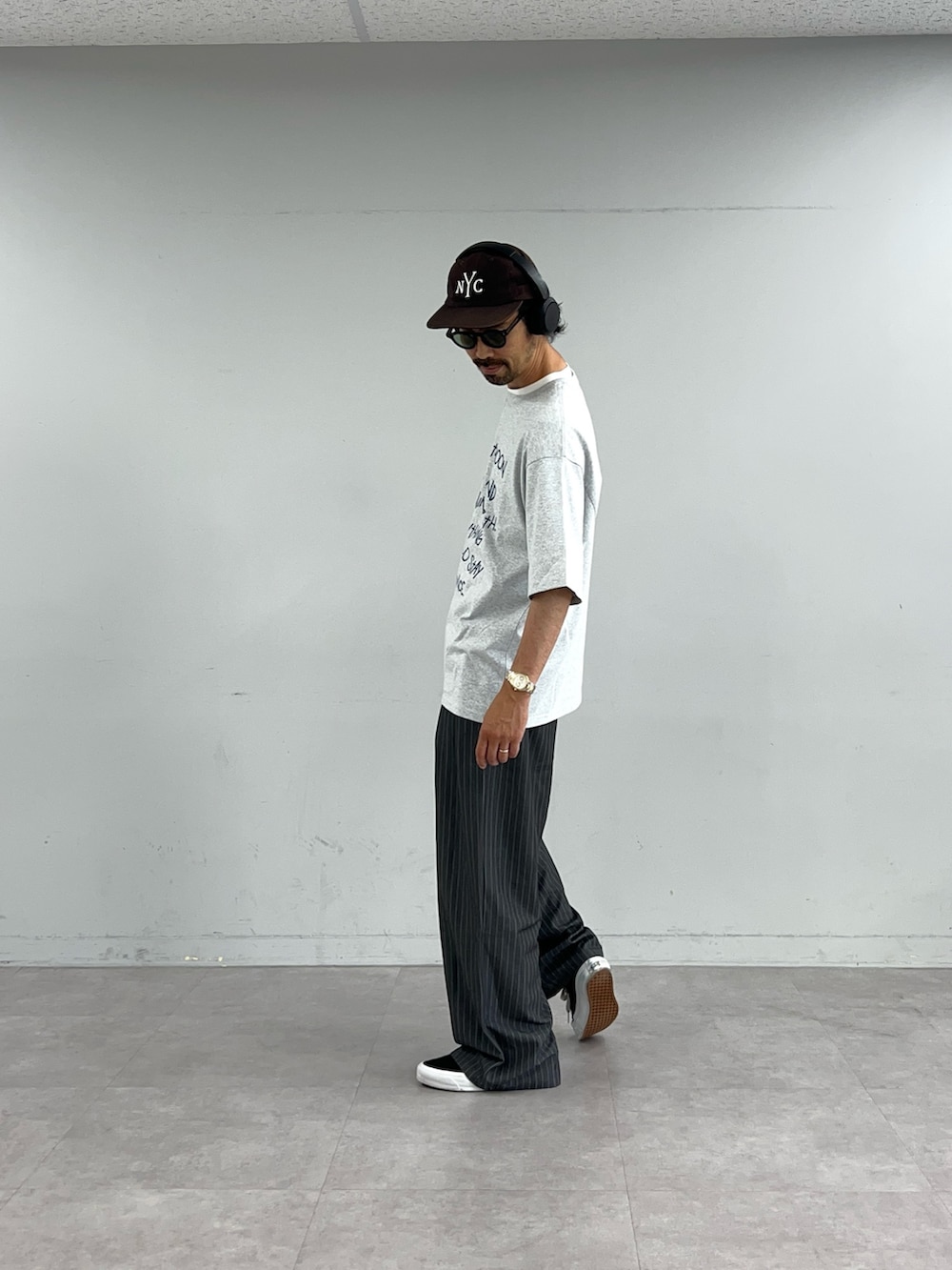 グレー系のTシャツ/カットソー、グレー系のスラックスを着用したメンズの夏コーディネートの2枚目の写真