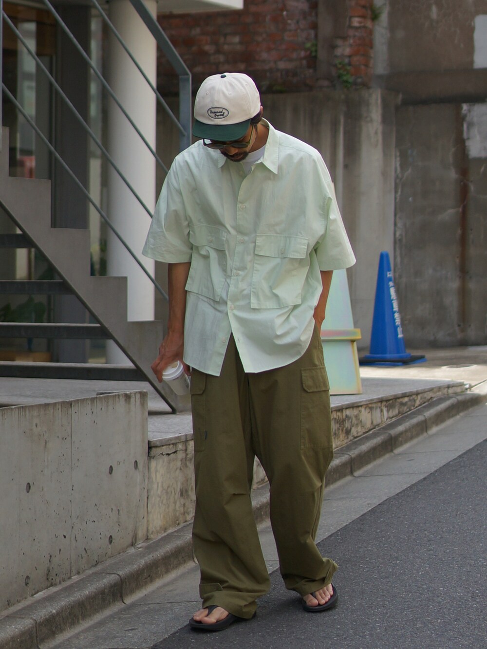 グリーン系のカーゴパンツ、グリーン系のシャツ/ブラウス、ブラック系のサンダルを着用したメンズの春コーディネートの2枚目の写真