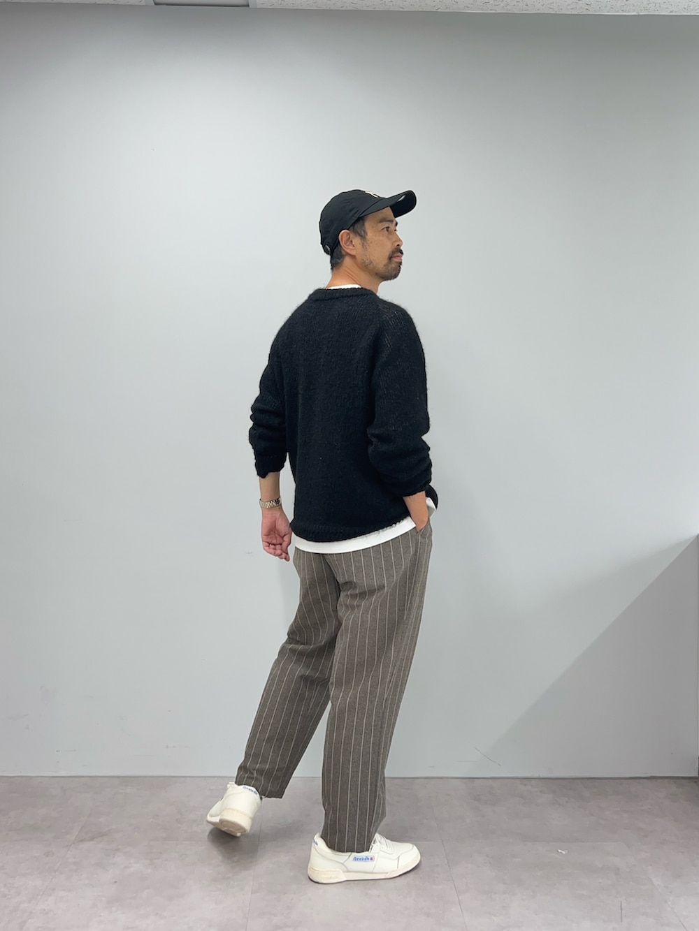 ブラック系のニット/セーター、ブラウン系のパンツを着用したメンズの秋コーディネートの3枚目の写真