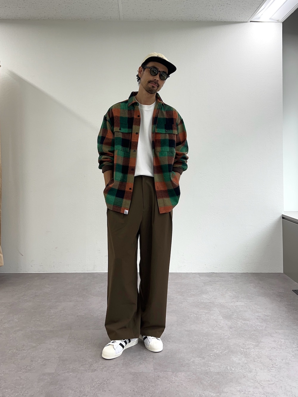 グリーン系のシャツ/ブラウス、ブラウン系のスラックスを着用したメンズの秋コーディネートの2枚目の写真