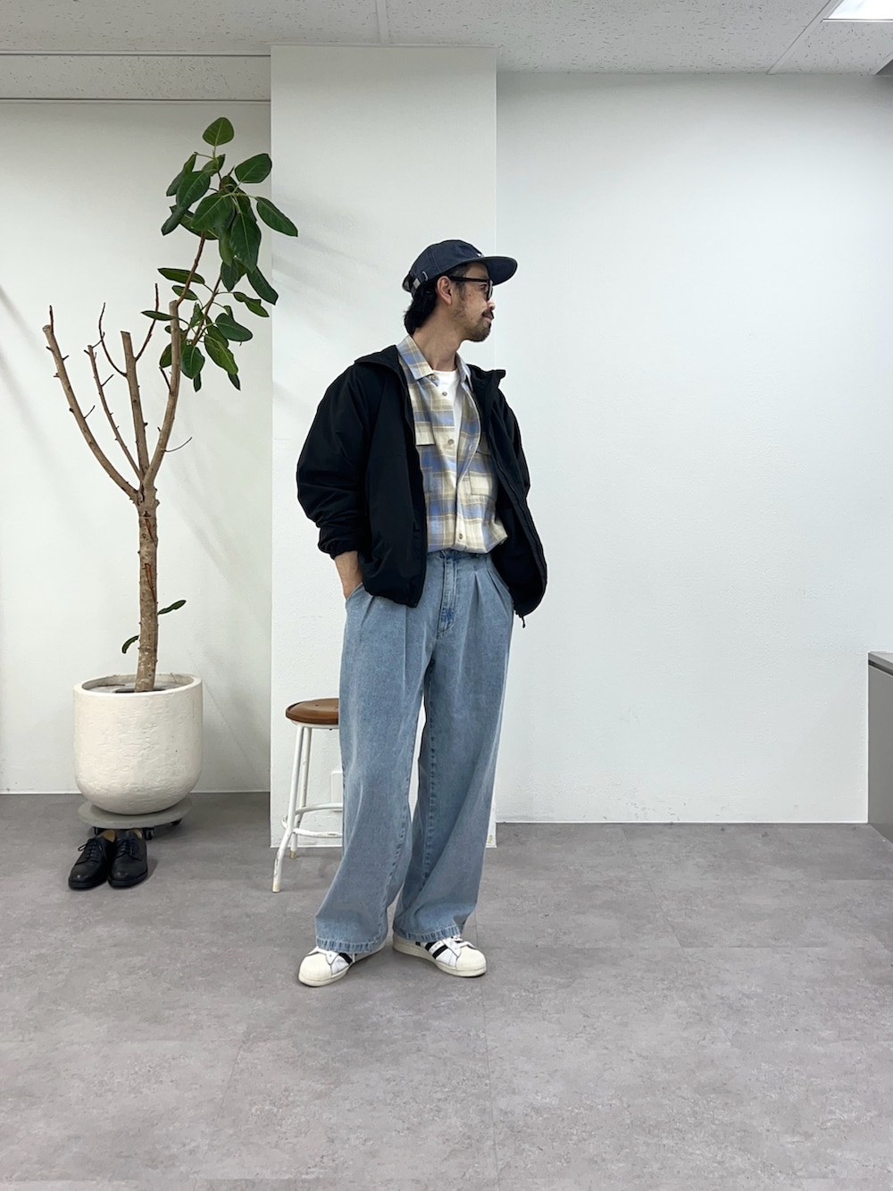 ブラック系のマウンテンパーカー、ブルー系のデニムパンツ、ベージュ系のシャツ/ブラウスを着用したメンズの春コーディネートの3枚目の写真