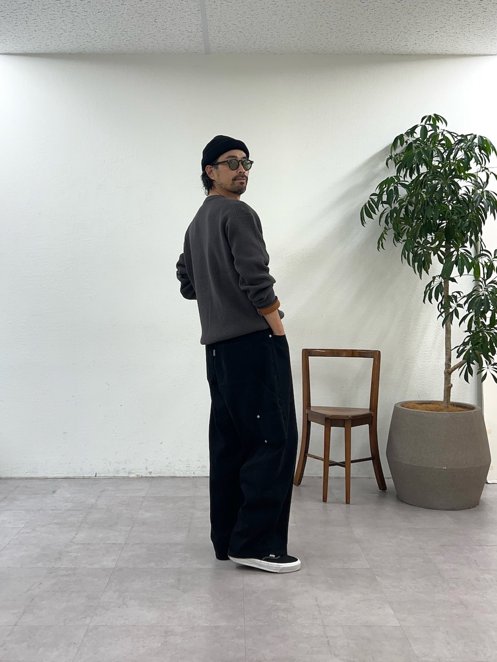 グレー系のニット/セーター、ブラック系のデニムパンツ、ブラック系のニットキャップ/ビーニーを着用したメンズの秋コーディネートの3枚目の写真