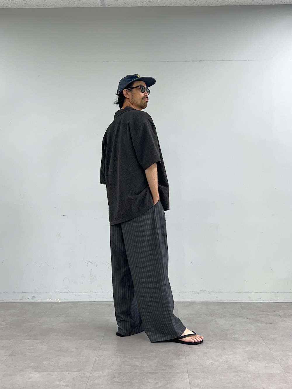 グレー系のシャツ/ブラウス、グレー系のスラックスを着用したメンズの夏コーディネートの2枚目の写真