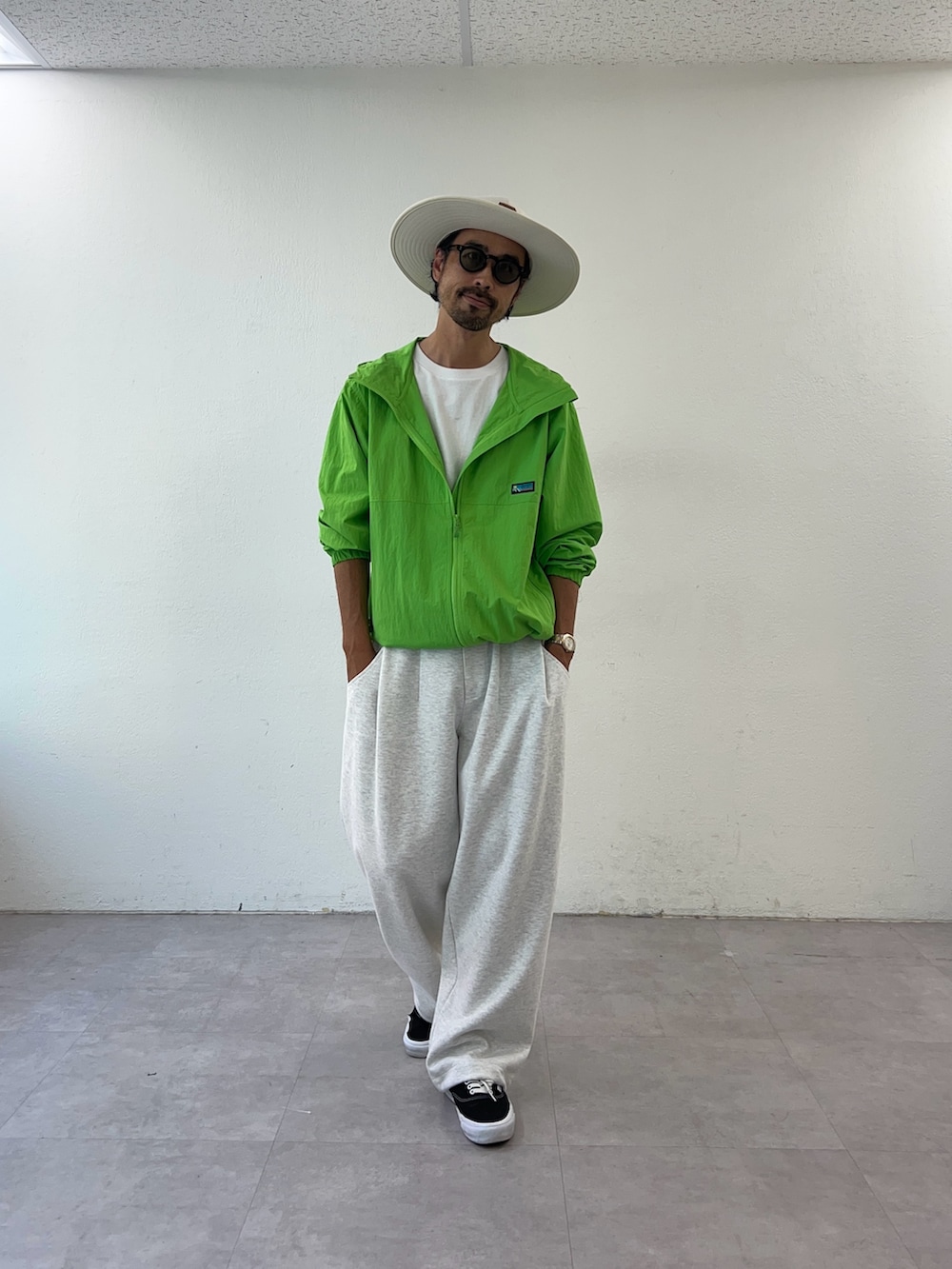 グリーン系のパーカー、ホワイト系のハットを着用したメンズの秋コーディネートの3枚目の写真