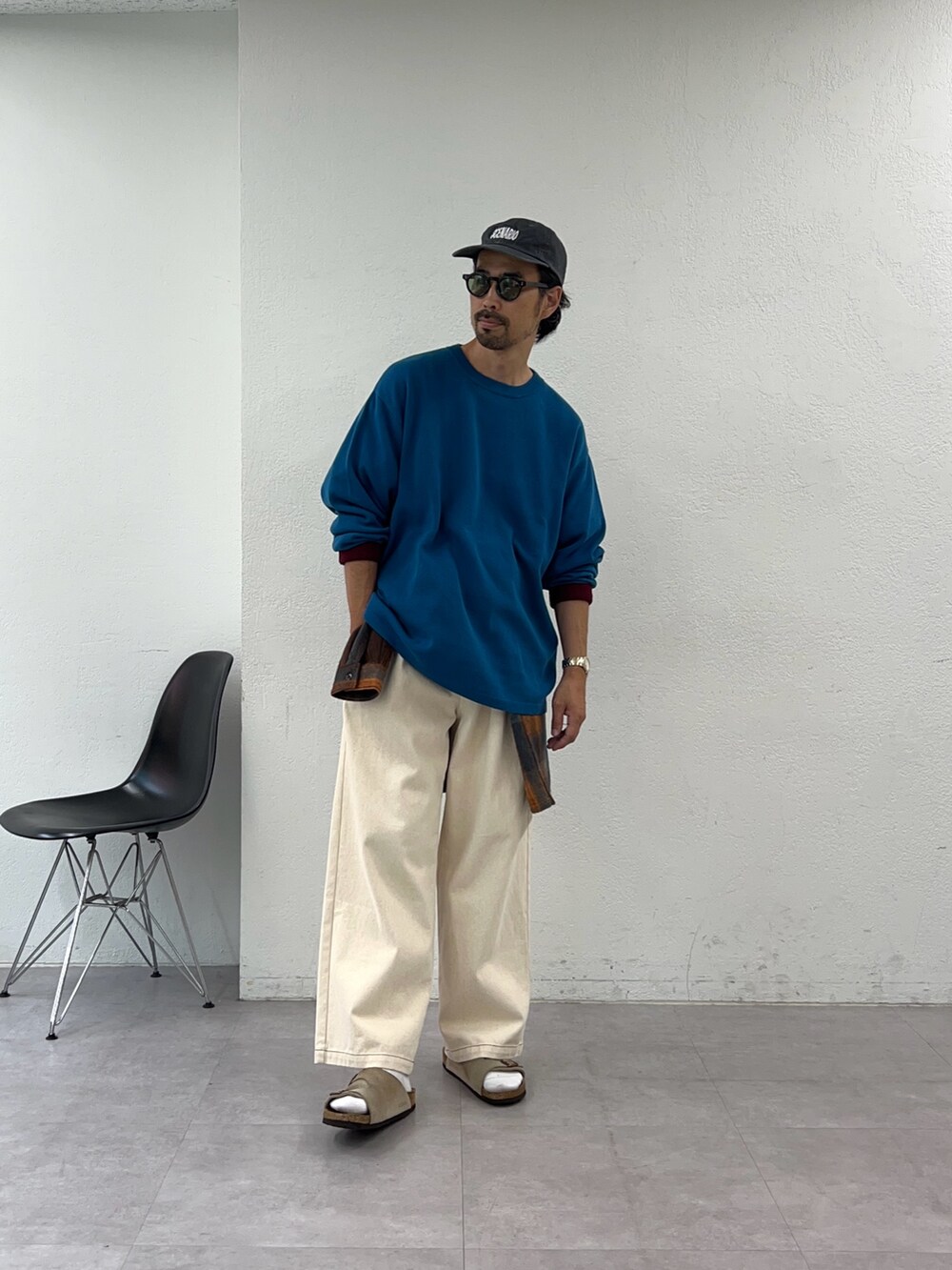 ブルー系のニット/セーター、オレンジ系のシャツ/ブラウスを着用したメンズの秋コーディネートの3枚目の写真