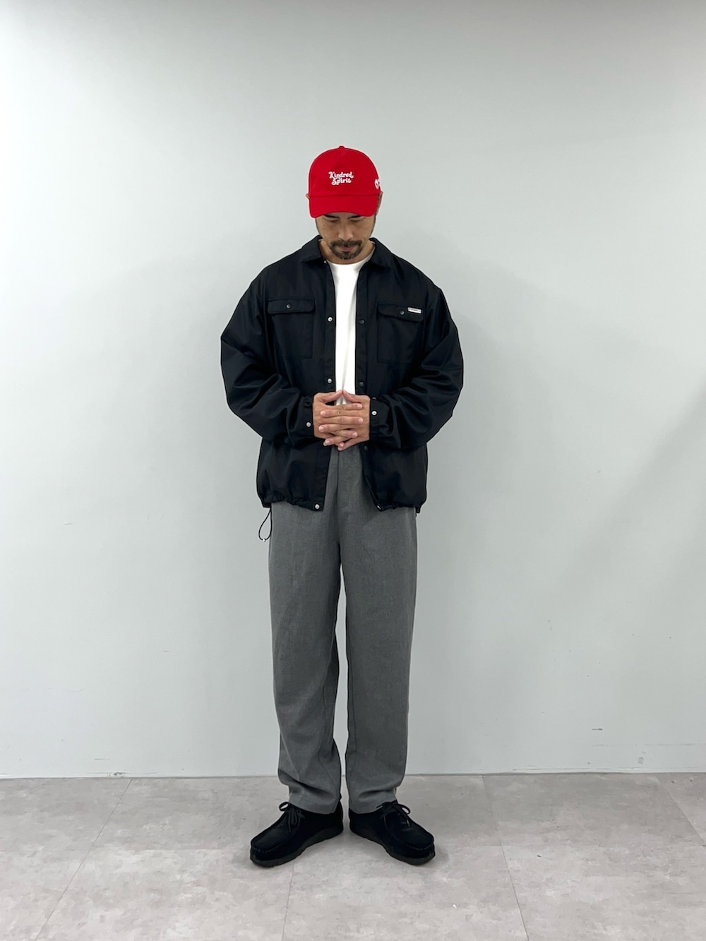 ブラック系のブルゾン、グレー系のチノパンツを着用したメンズの秋コーディネートの2枚目の写真