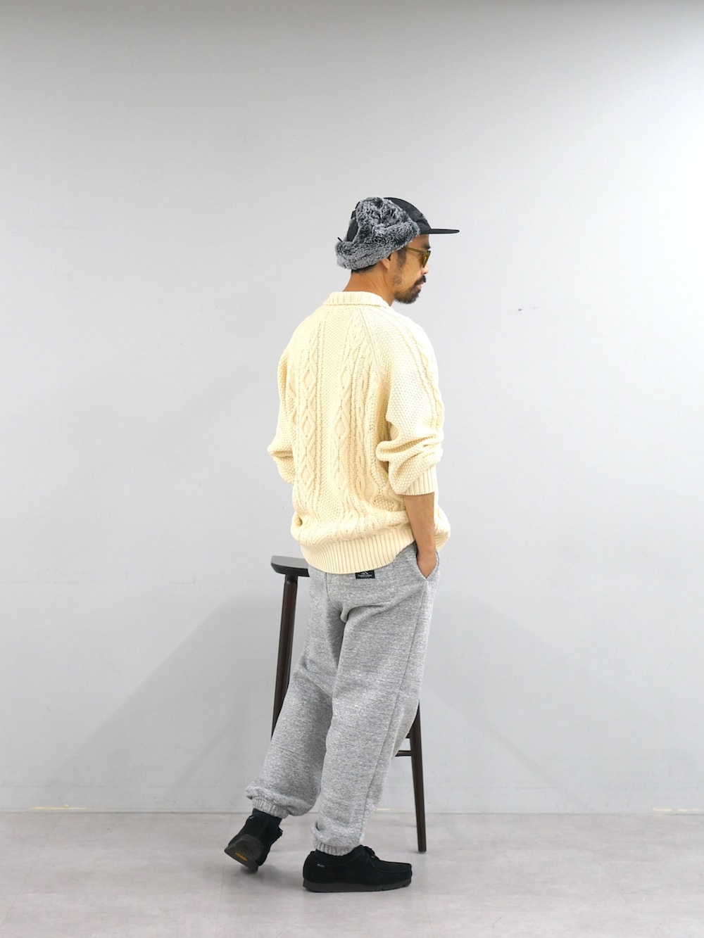 ホワイト系のカーディガン/ボレロ、グレー系のスウェットパンツ、ブラック系のキャップを着用したメンズの冬コーディネートの3枚目の写真