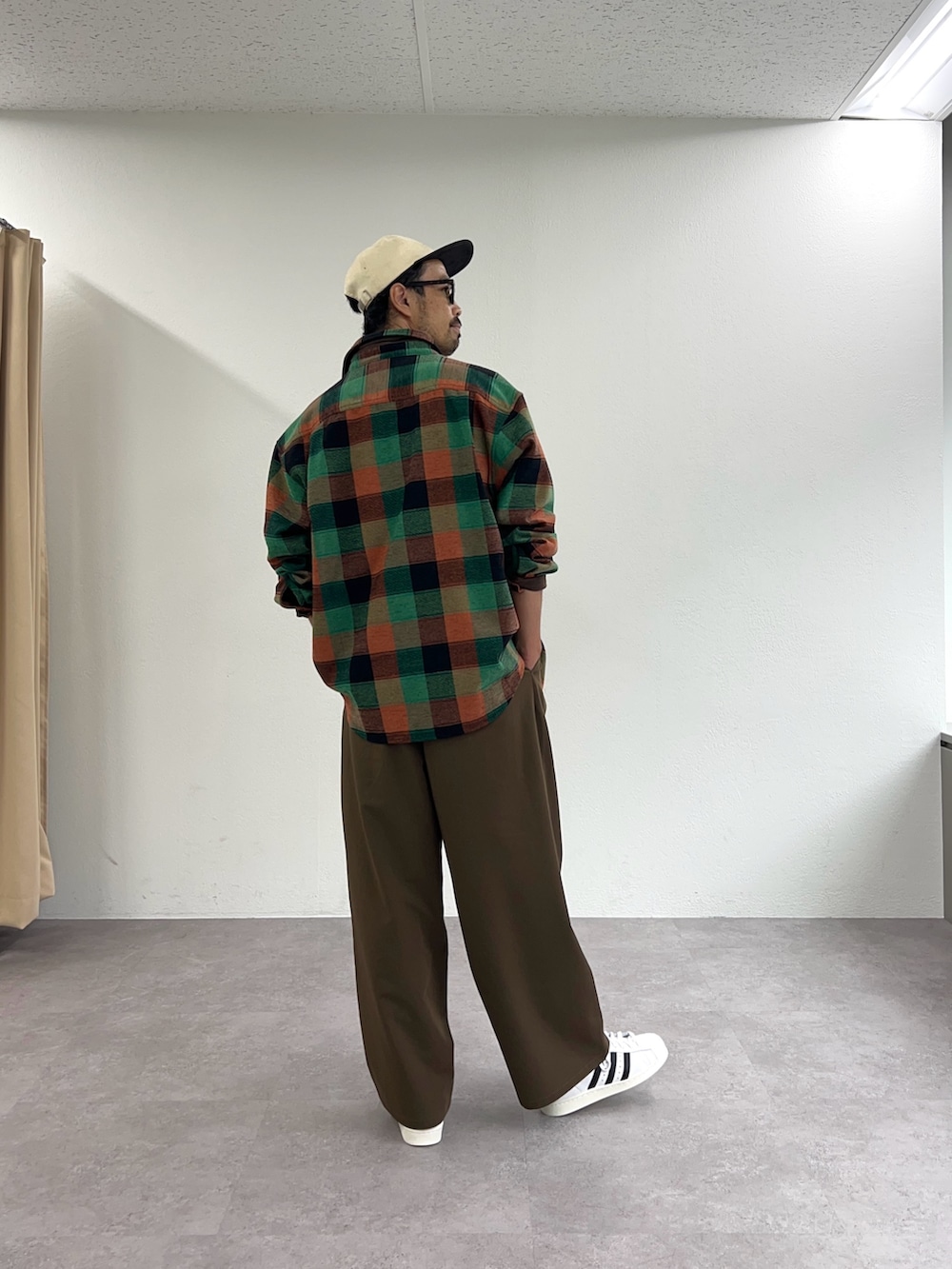 グリーン系のシャツ/ブラウス、ブラウン系のスラックスを着用したメンズの秋コーディネートの3枚目の写真