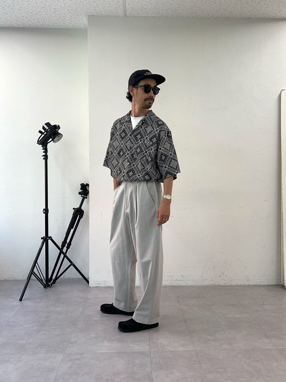 ブラック系のシャツ/ブラウス、グレー系のチノパンツ、ブラック系のキャップを着用したメンズの夏コーディネートの3枚目の写真