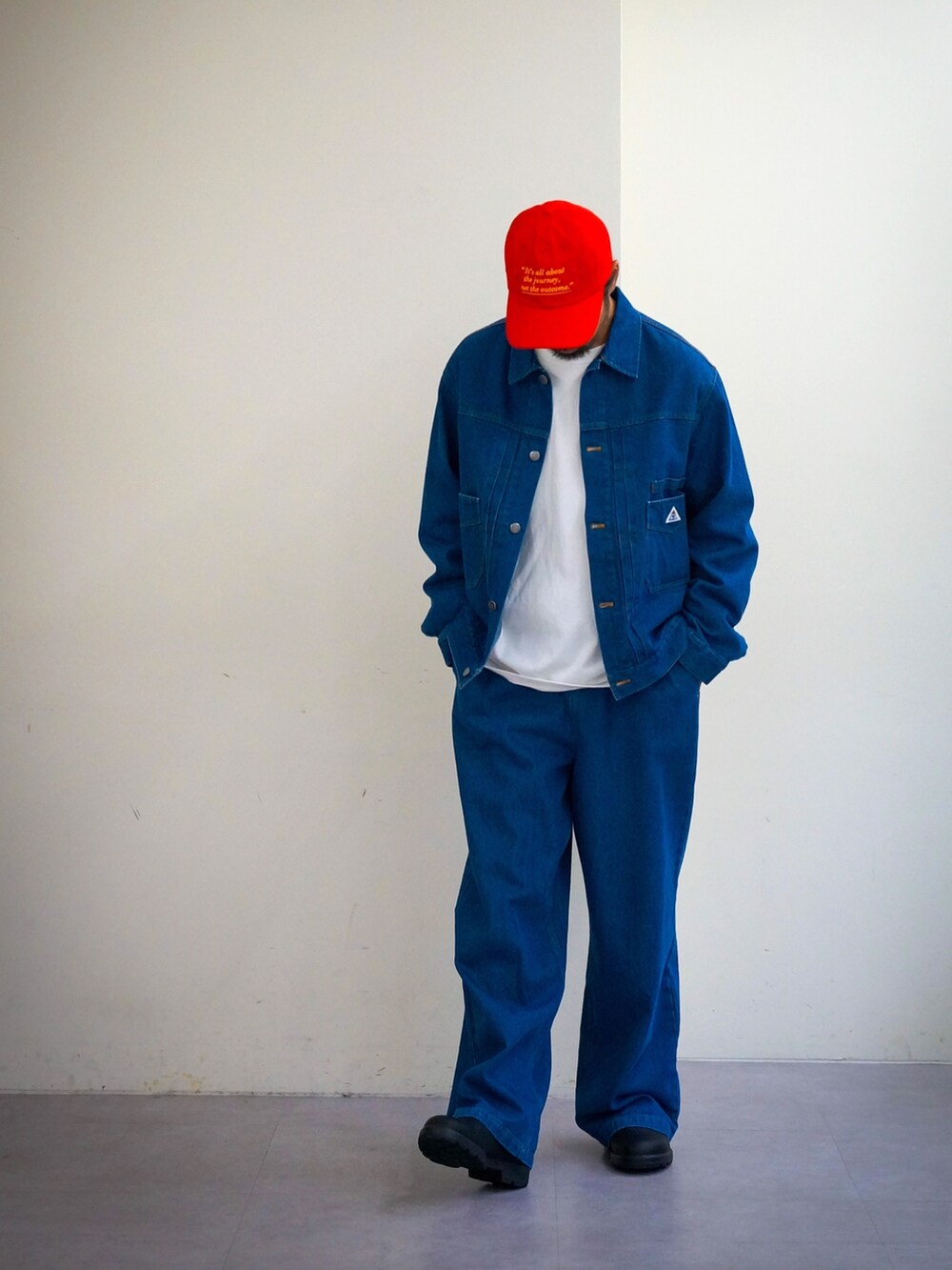 ブルー系のデニムジャケット、ブルー系のデニムパンツ、レッド系のキャップを着用したメンズの冬コーディネートの3枚目の写真