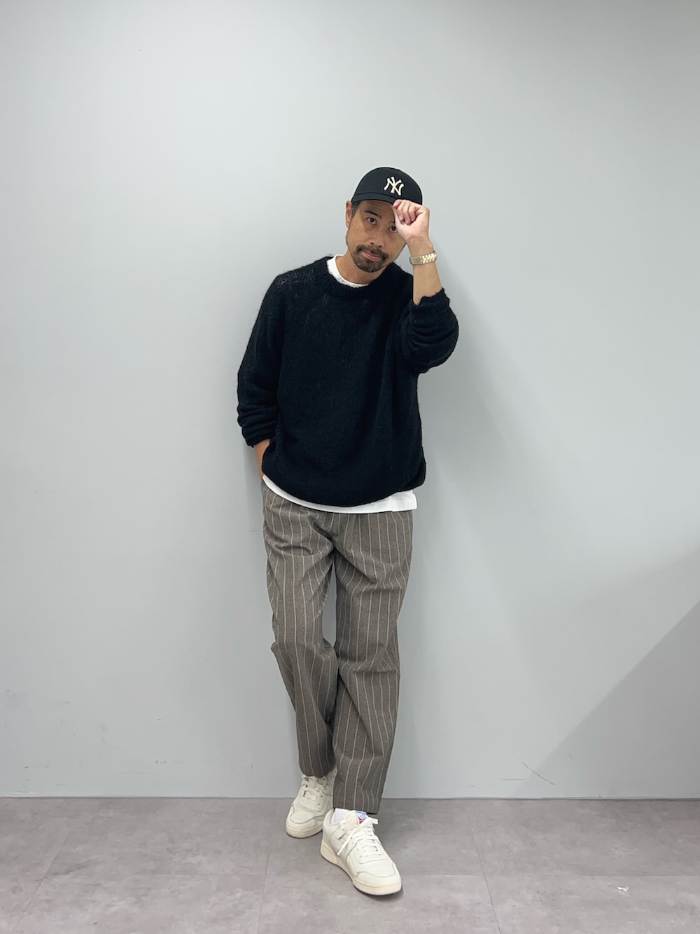 ブラック系のニット/セーター、ブラウン系のパンツを着用したメンズの秋コーディネートの4枚目の写真