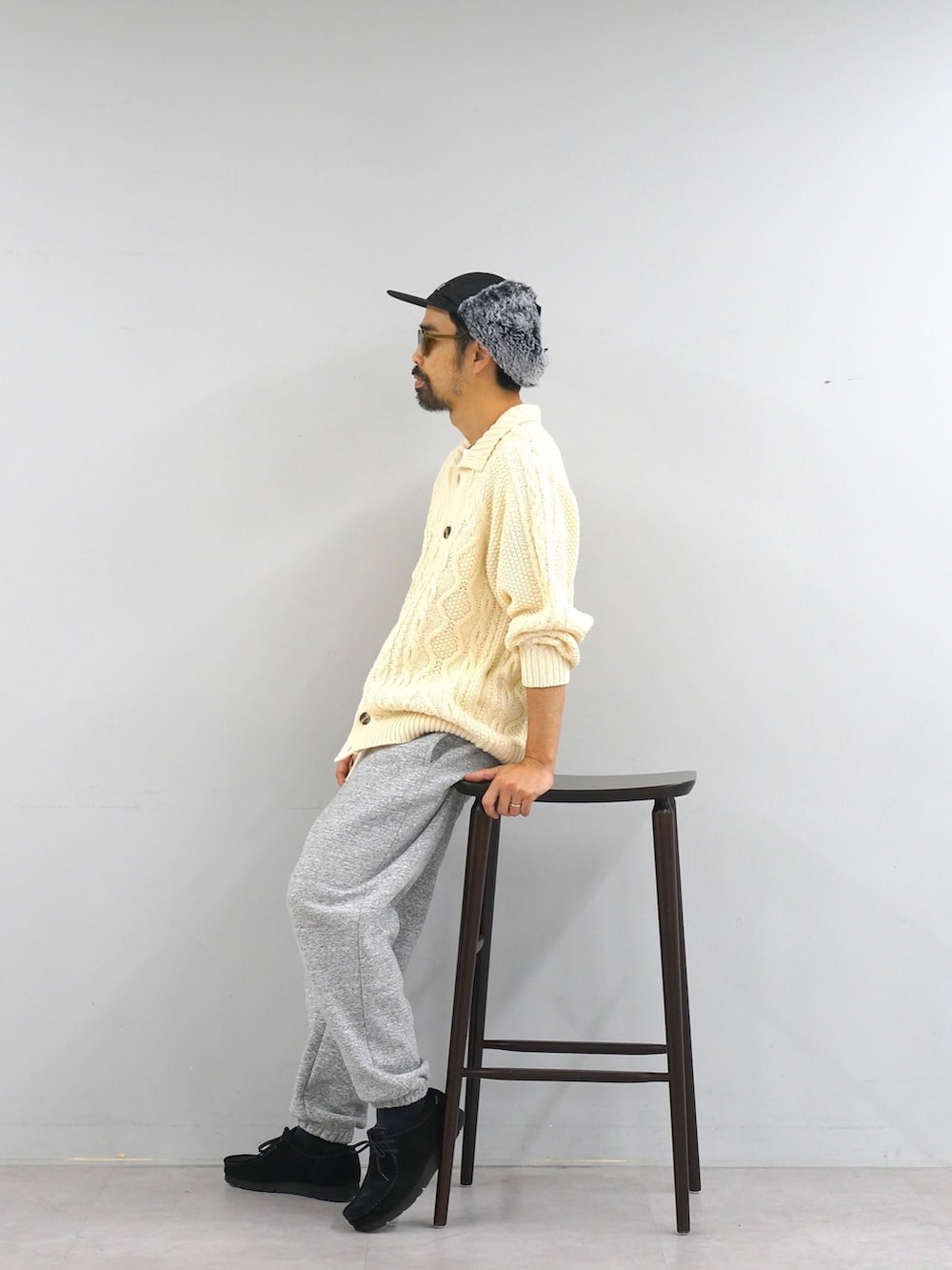 ホワイト系のカーディガン/ボレロ、グレー系のスウェットパンツ、ブラック系のキャップを着用したメンズの冬コーディネートの2枚目の写真