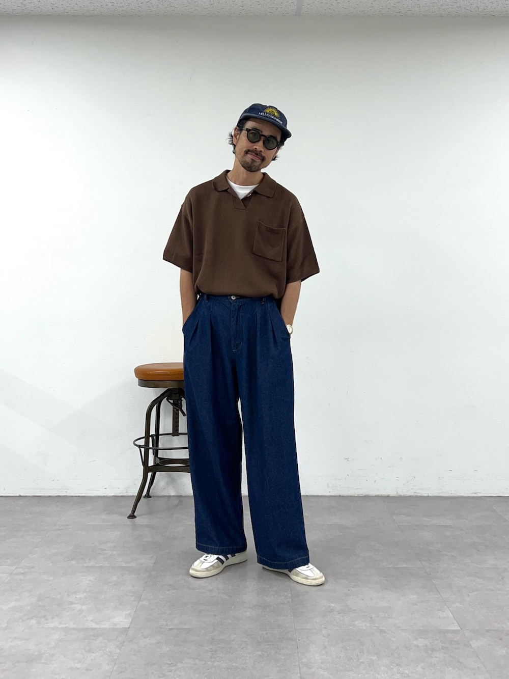 ブラウン系のポロシャツ、ブルー系のデニムパンツを着用したメンズの夏コーディネートの2枚目の写真