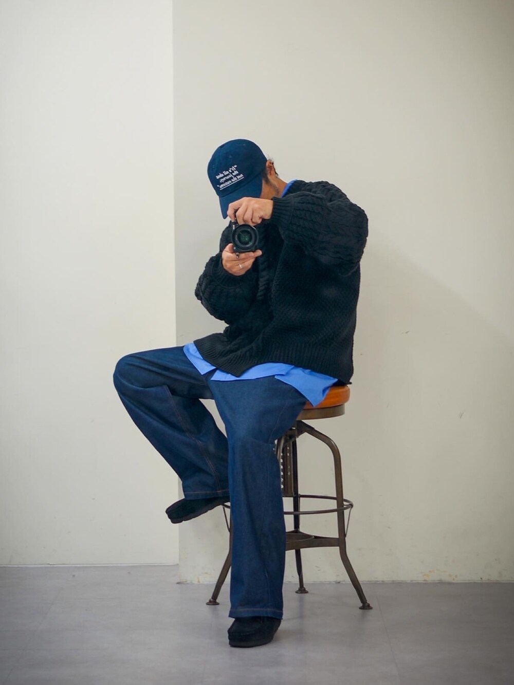 ブラック系のニット/セーター、ブルー系のデニムパンツ、ブルー系のキャップを着用したメンズの秋コーディネートの3枚目の写真