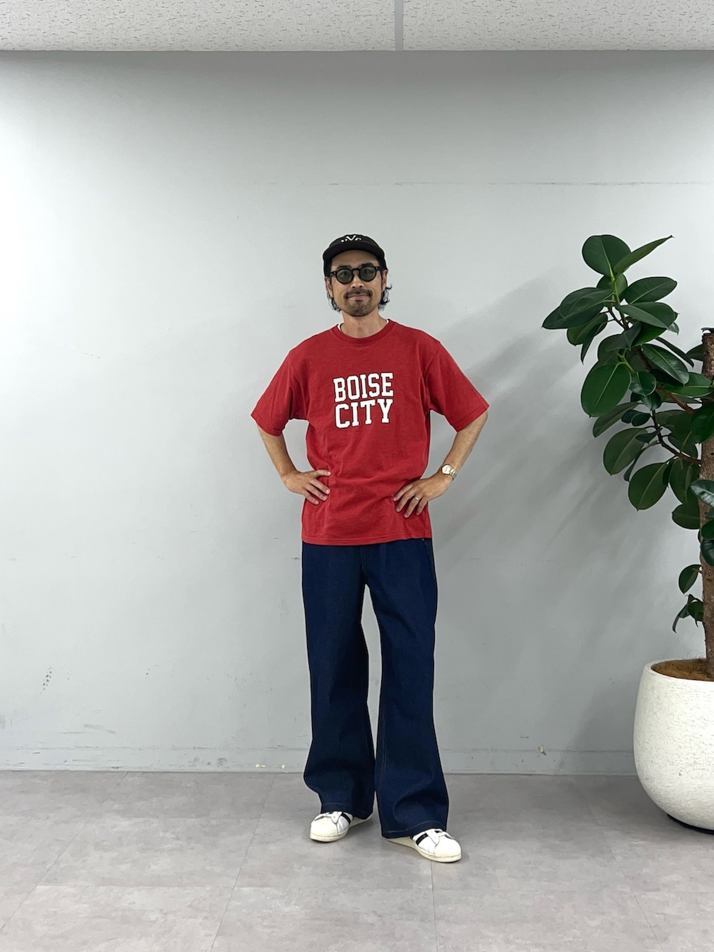 レッド系のTシャツ/カットソー、ブルー系のデニムパンツを着用したメンズの夏コーディネートの2枚目の写真