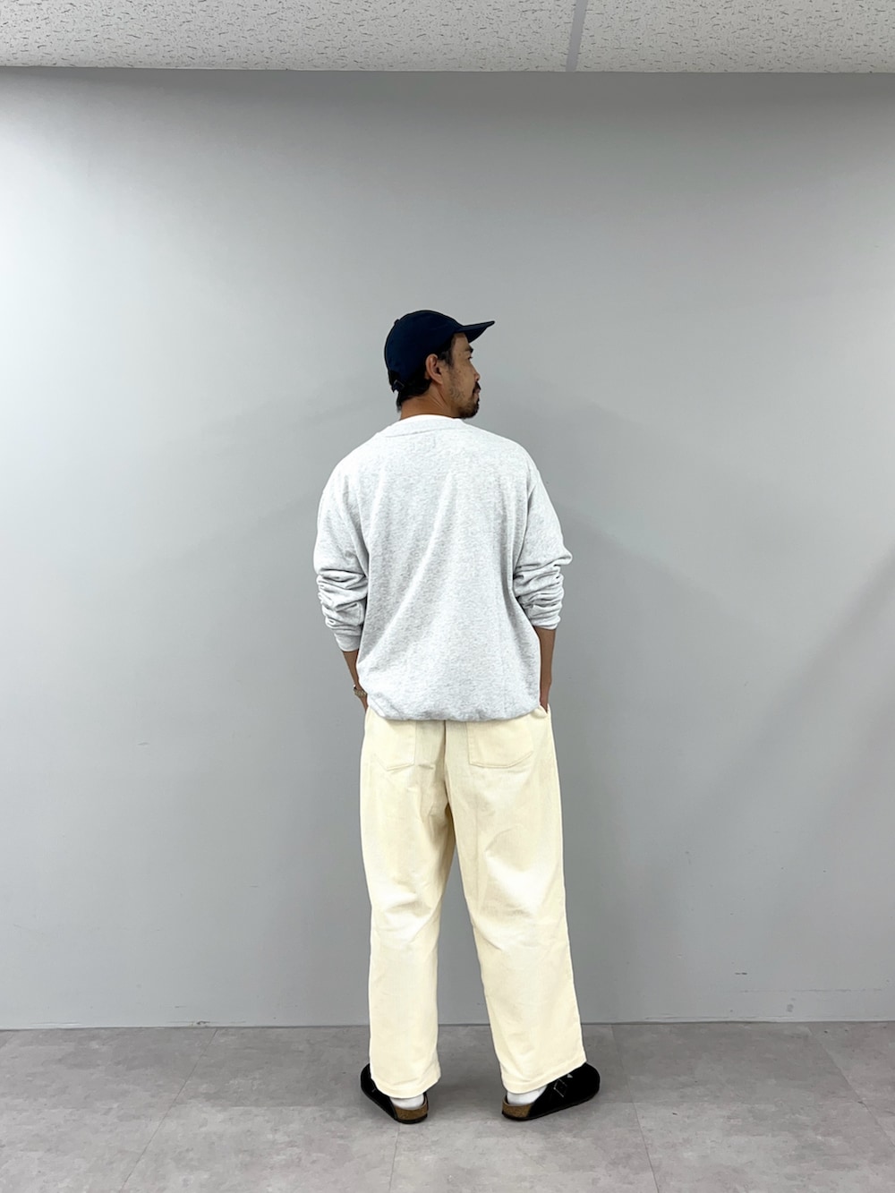 グレー系のスウェット、ホワイト系のパンツを着用したレディースの秋コーディネートの4枚目の写真