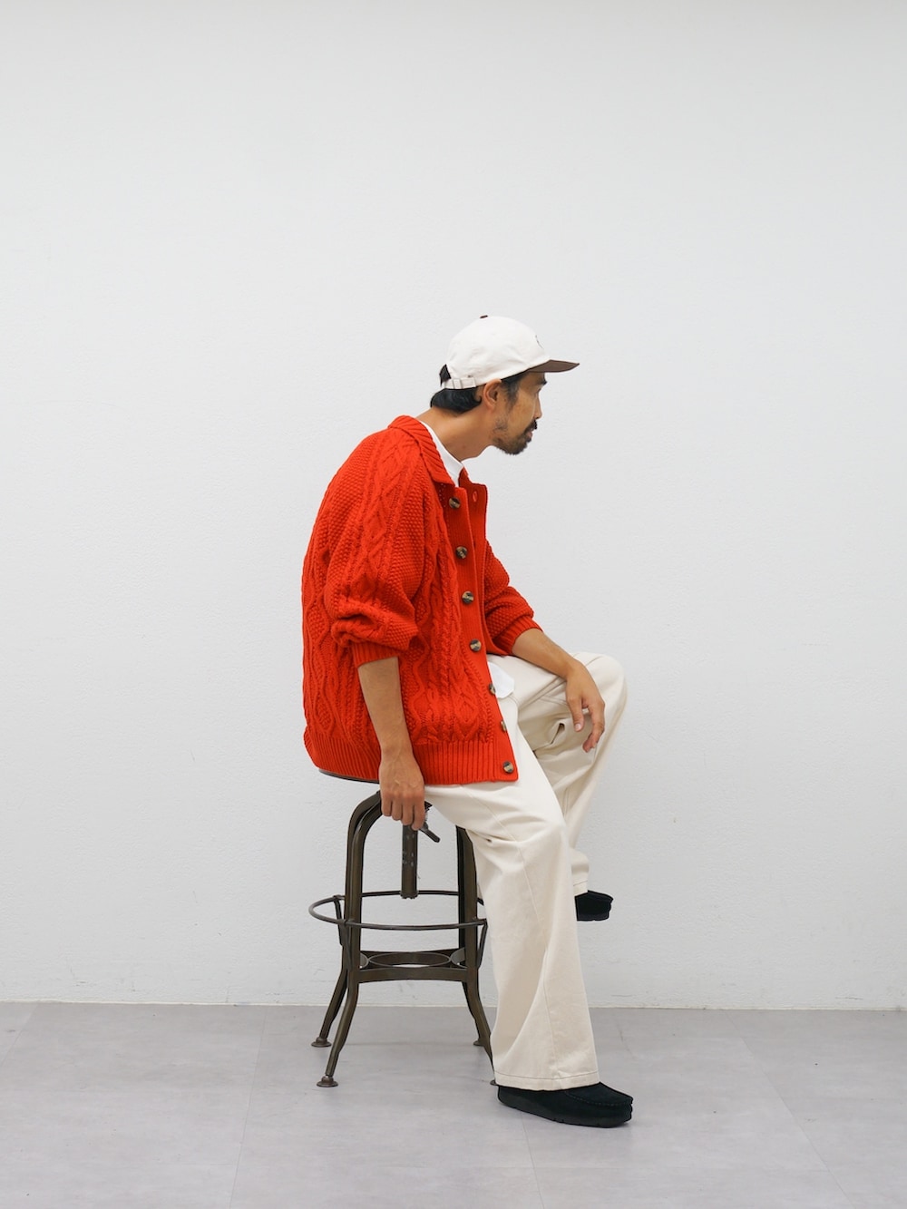 レッド系のカーディガン/ボレロ、ホワイト系のデニムパンツを着用したメンズの冬コーディネートの2枚目の写真