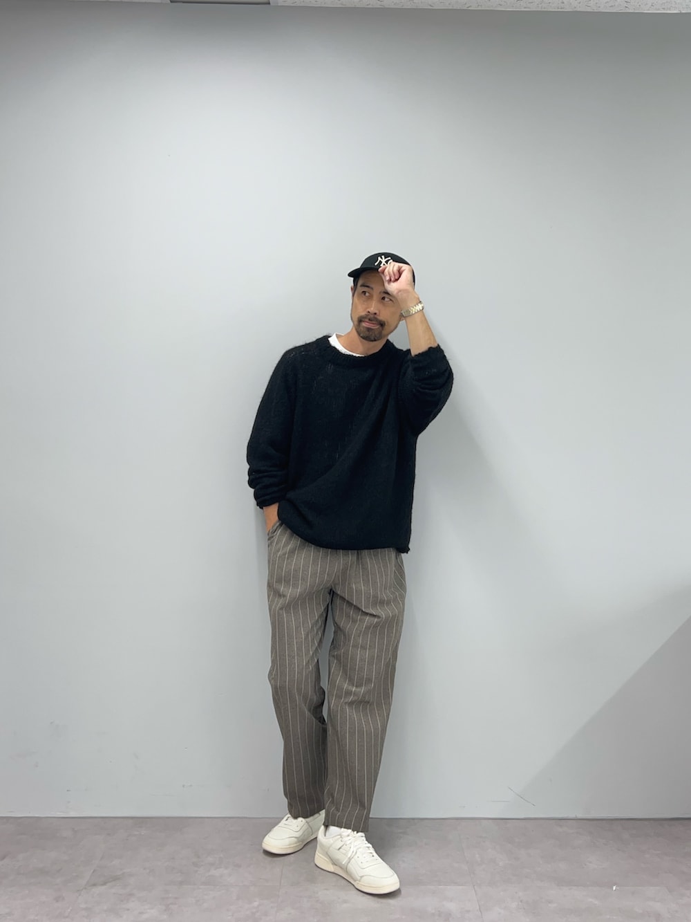 ブラック系のニット/セーター、ブラウン系のパンツを着用したメンズの秋コーディネートの2枚目の写真