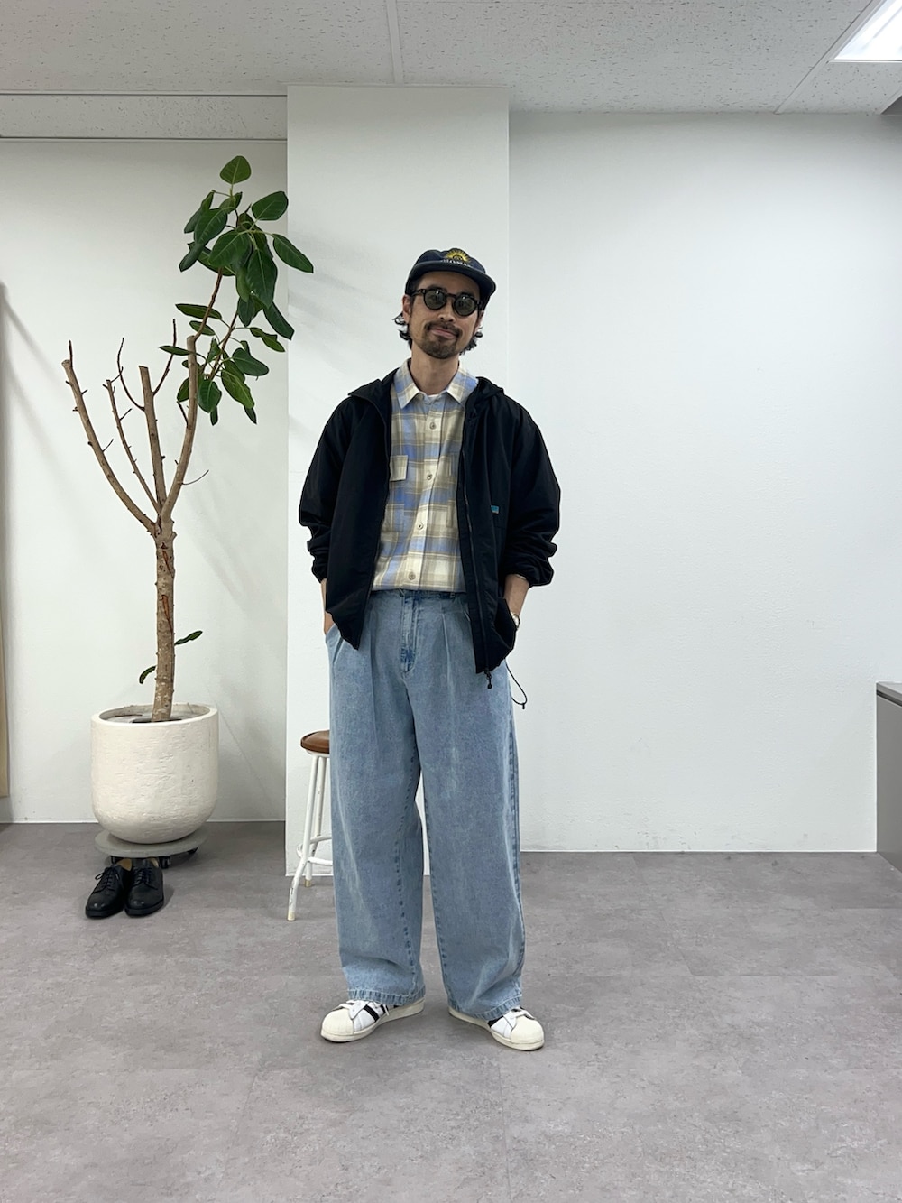 ブラック系のマウンテンパーカー、ブルー系のデニムパンツ、ベージュ系のシャツ/ブラウスを着用したメンズの春コーディネートの4枚目の写真