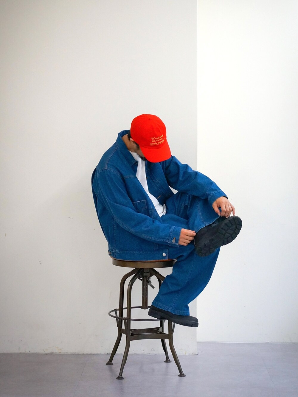 ブルー系のデニムジャケット、ブルー系のデニムパンツ、レッド系のキャップを着用したメンズの冬コーディネートの4枚目の写真