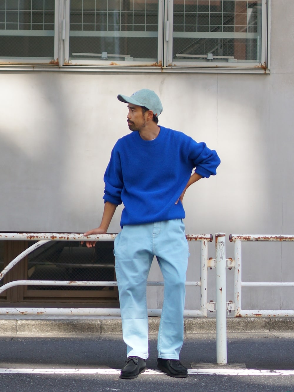 ブルー系のニット/セーター、ブルー系のデニムパンツ、ブラック系のブーツを着用したメンズの夏コーディネートの3枚目の写真