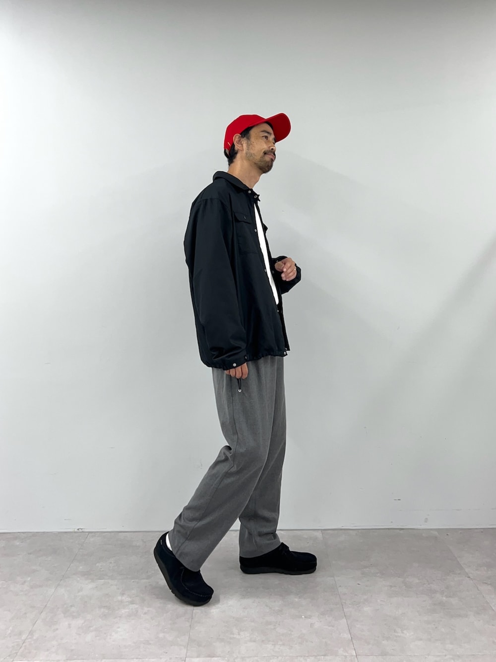 ブラック系のブルゾン、グレー系のチノパンツを着用したメンズの秋コーディネートの3枚目の写真