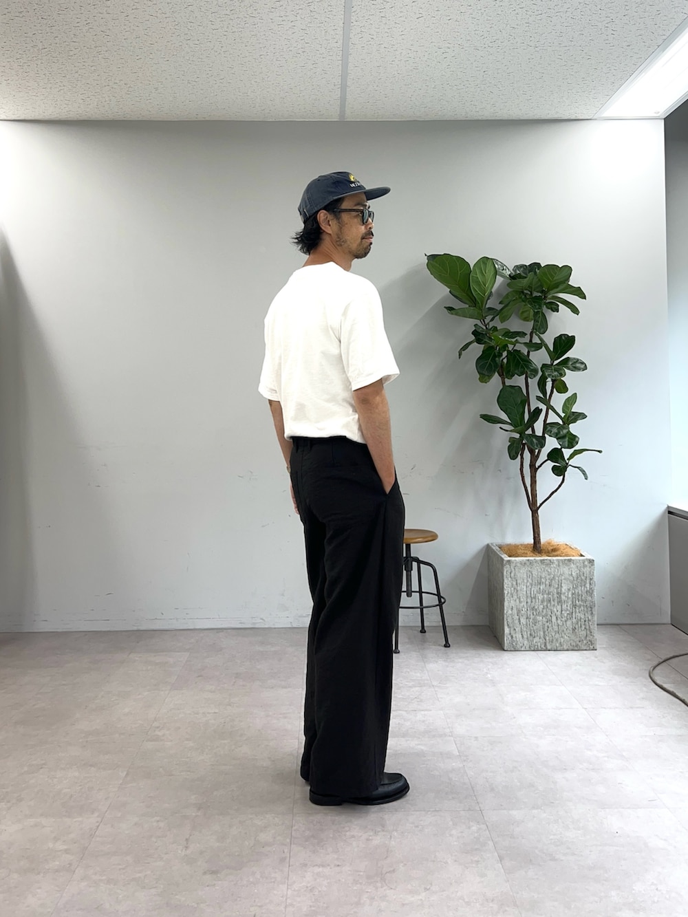 ホワイト系のTシャツ/カットソー、ブラック系のスラックスを着用したメンズの夏コーディネートの2枚目の写真