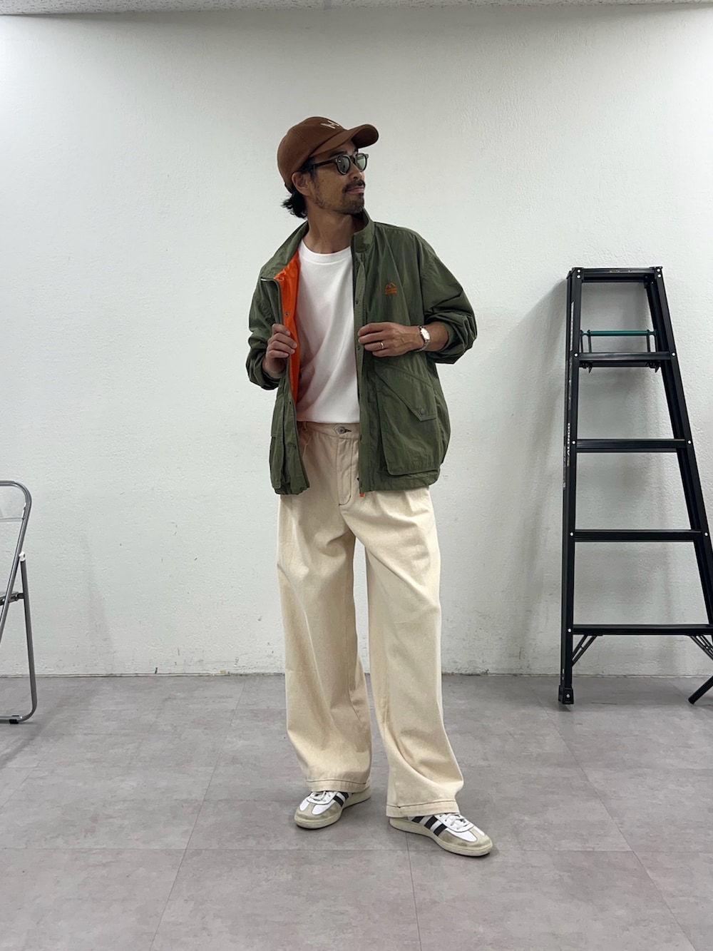 グリーン系のナイロンジャケットを着用したメンズの秋コーディネートの3枚目の写真