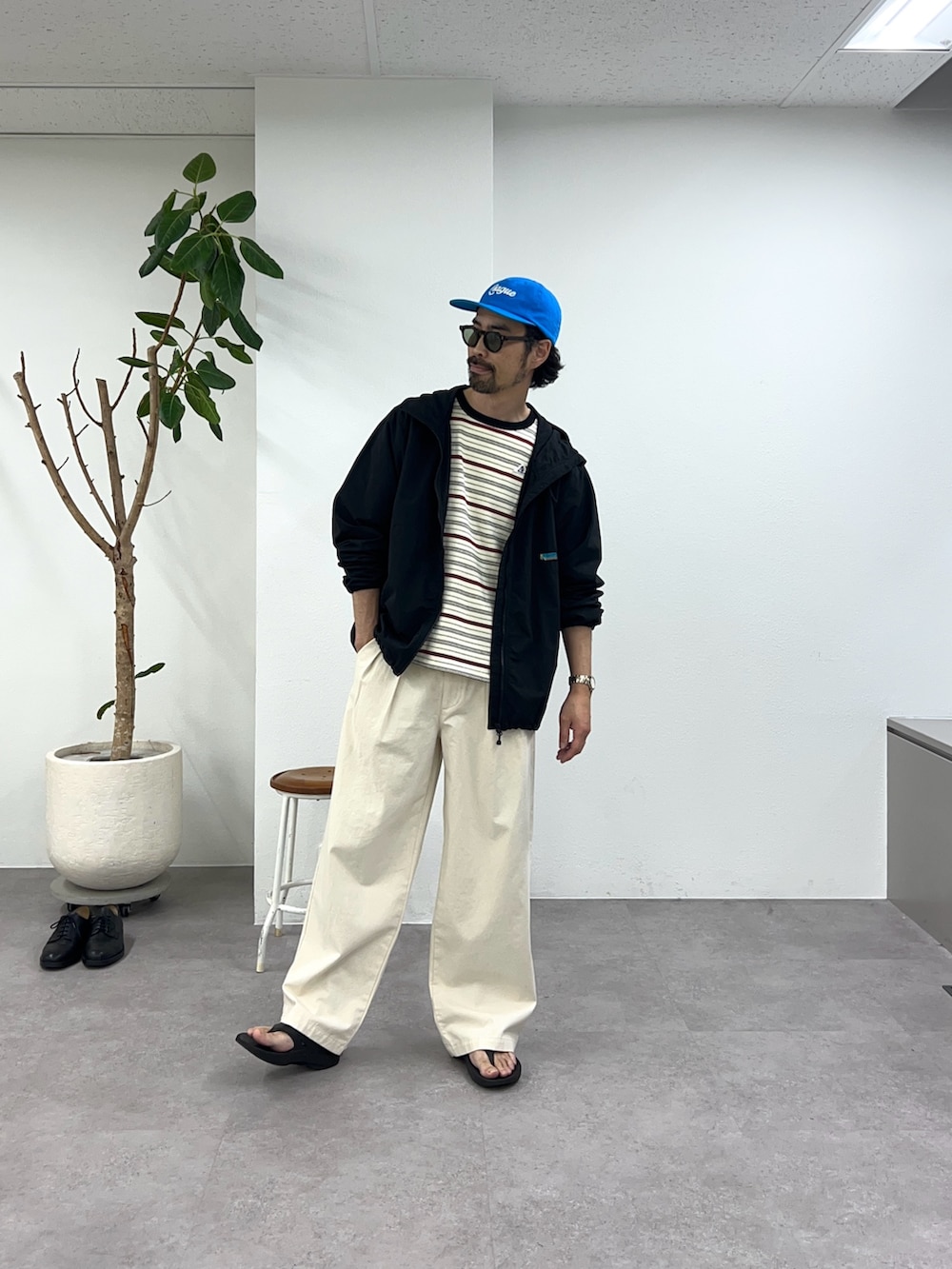 ブラック系のマウンテンパーカー、ホワイト系のデニムパンツ、ホワイト系のTシャツ/カットソーを着用したメンズの春コーディネートの2枚目の写真