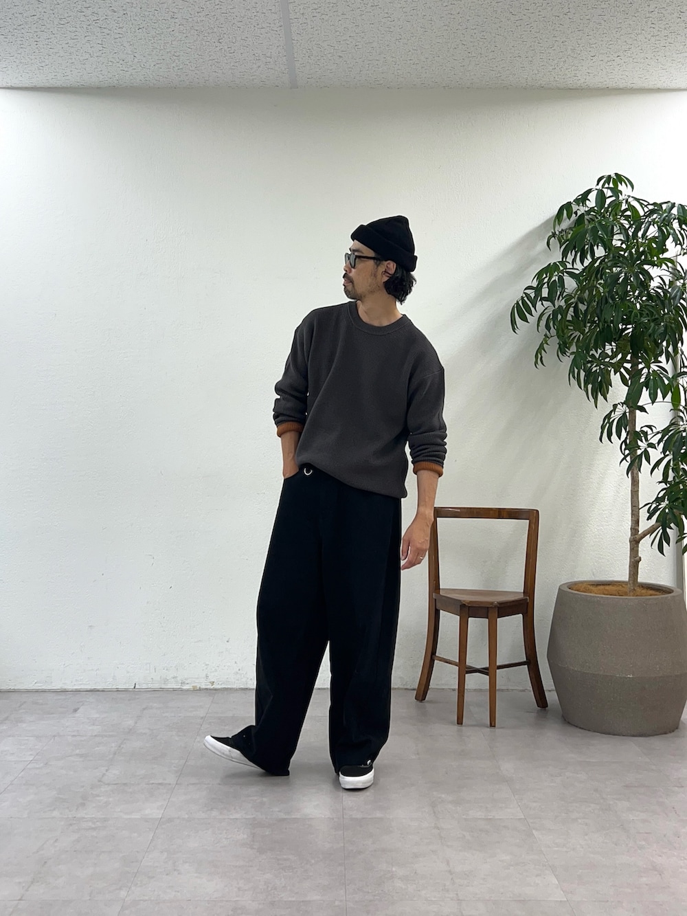 グレー系のニット/セーター、ブラック系のデニムパンツ、ブラック系のニットキャップ/ビーニーを着用したメンズの秋コーディネートの2枚目の写真
