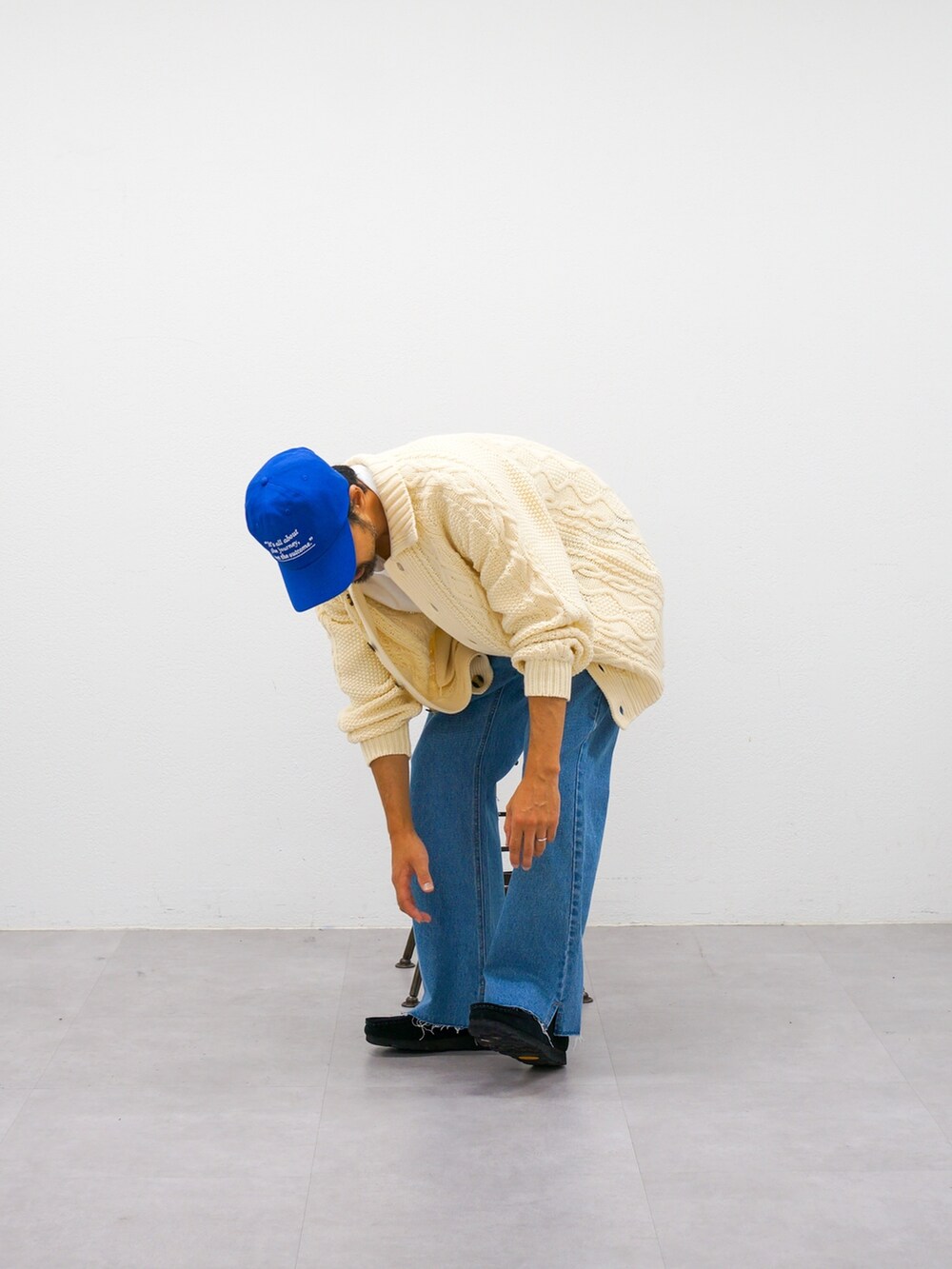 ホワイト系のカーディガン/ボレロ、ブルー系のデニムパンツ、ブルー系のキャップを着用したメンズの秋コーディネートの3枚目の写真