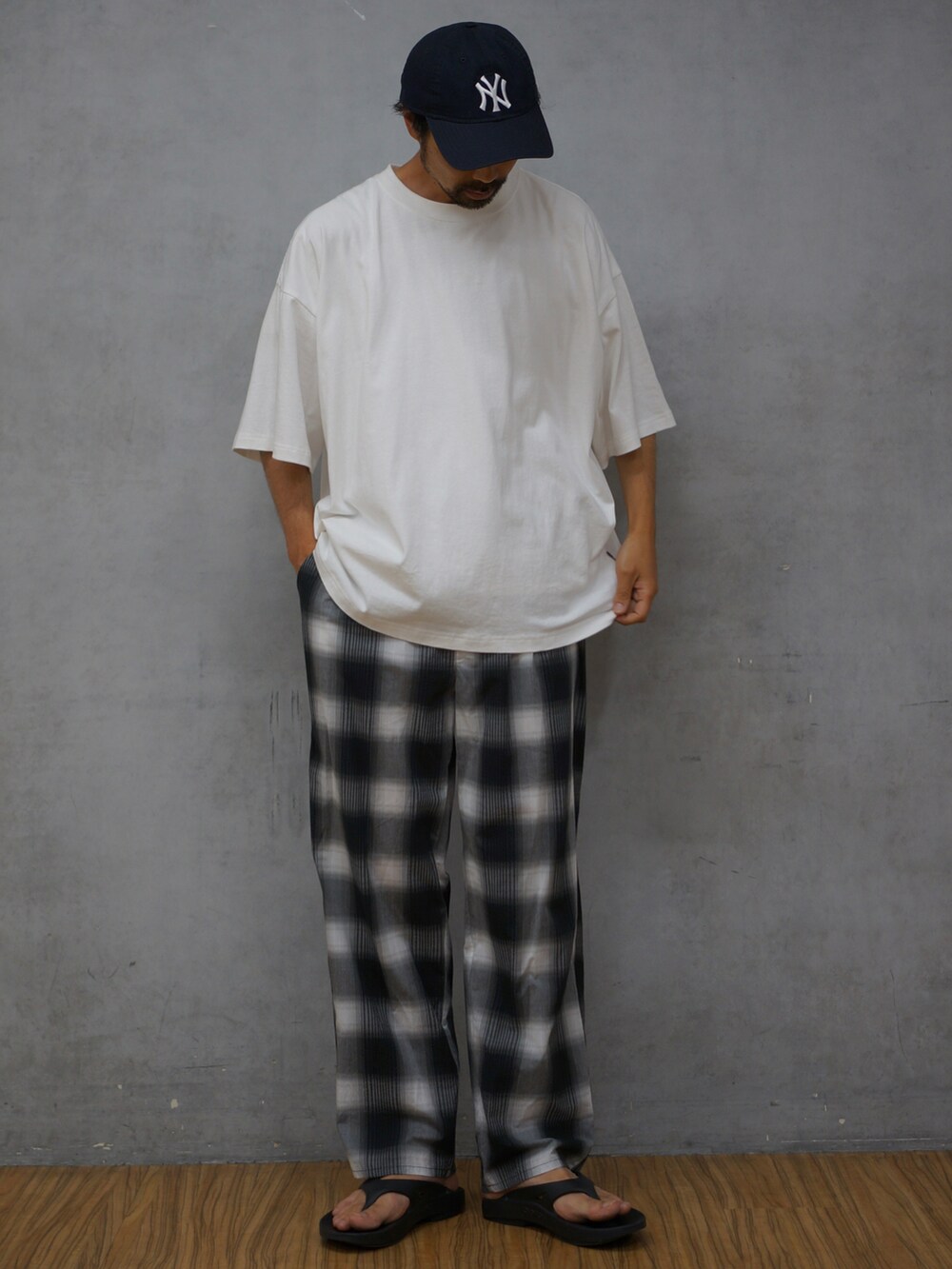 ホワイト系のTシャツ/カットソー、ブラック系のその他パンツ、ブラック系のサンダルを着用したメンズの夏コーディネートの2枚目の写真