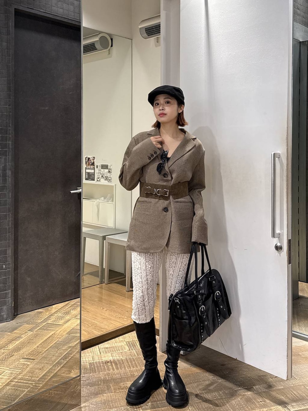 ブラック系のトートバッグ、ブラック系のブーツ、ホワイト系のその他パンツを着用したレディースの秋コーディネートの4枚目の写真