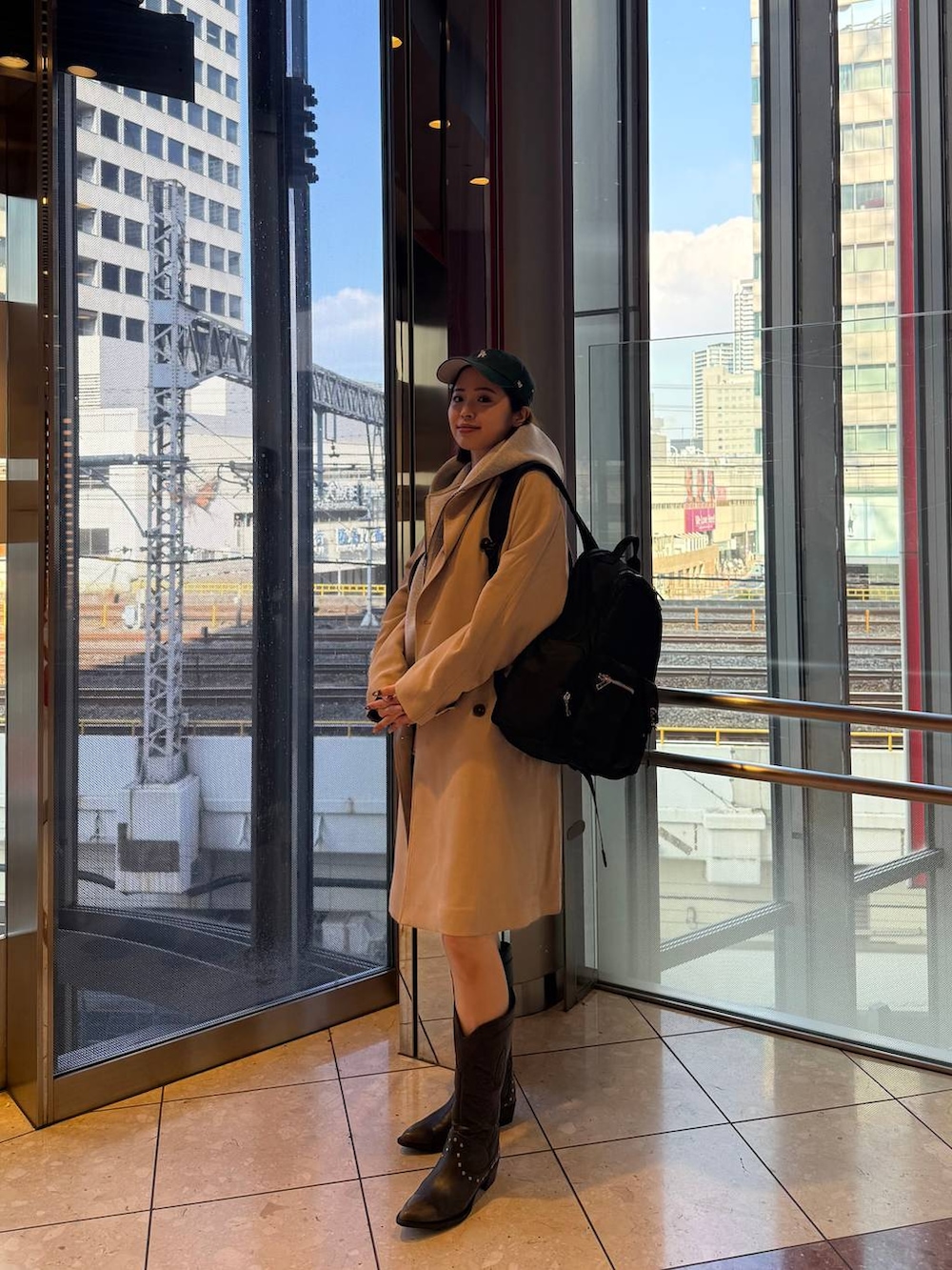 ブラック系のブーツ、ブラック系のバックパック/リュック、グレー系のブルゾンを着用したレディースの春コーディネートの4枚目の写真