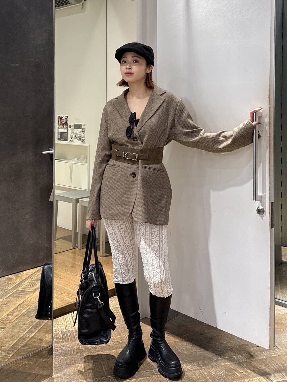 ブラック系のトートバッグ、ブラック系のブーツ、ホワイト系のその他パンツを着用したレディースの秋コーディネートの3枚目の写真