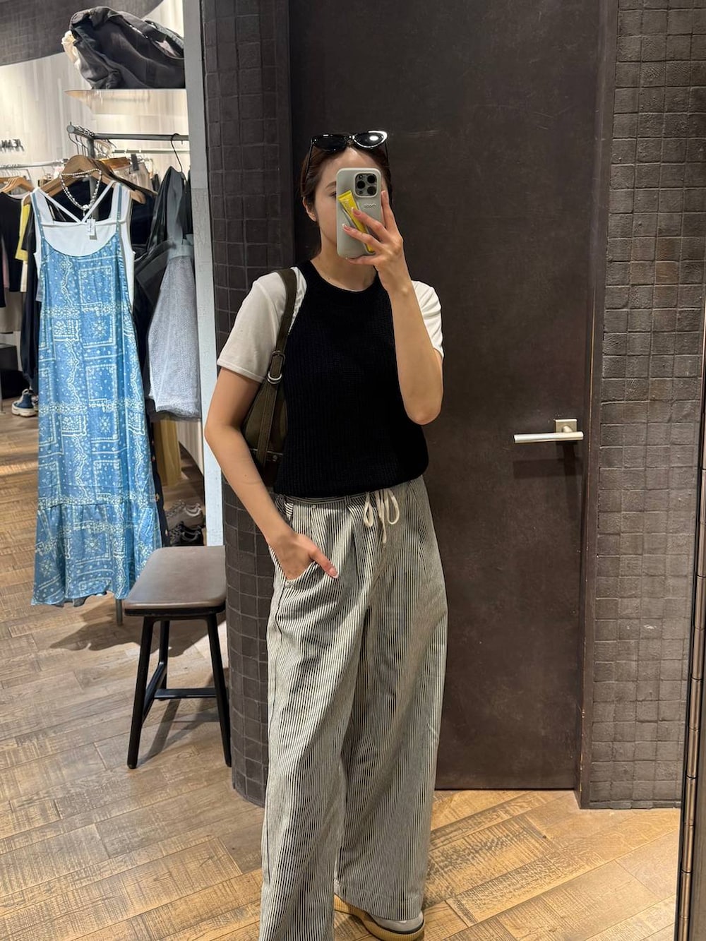 ホワイト系のTシャツ/カットソー、グリーン系のショルダーバッグ、ブラック系のタンクトップを着用したレディースの春コーディネートの2枚目の写真