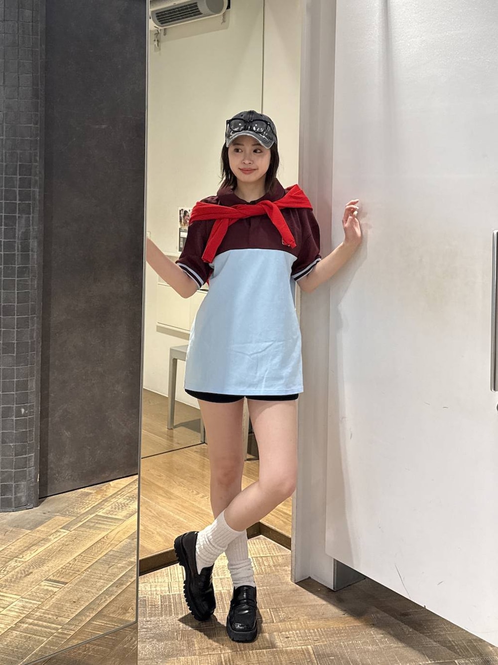 ブラック系のスウェットパンツ、レッド系のカーディガン/ボレロ、ブラック系のキャップを着用したレディースの春コーディネートの2枚目の写真