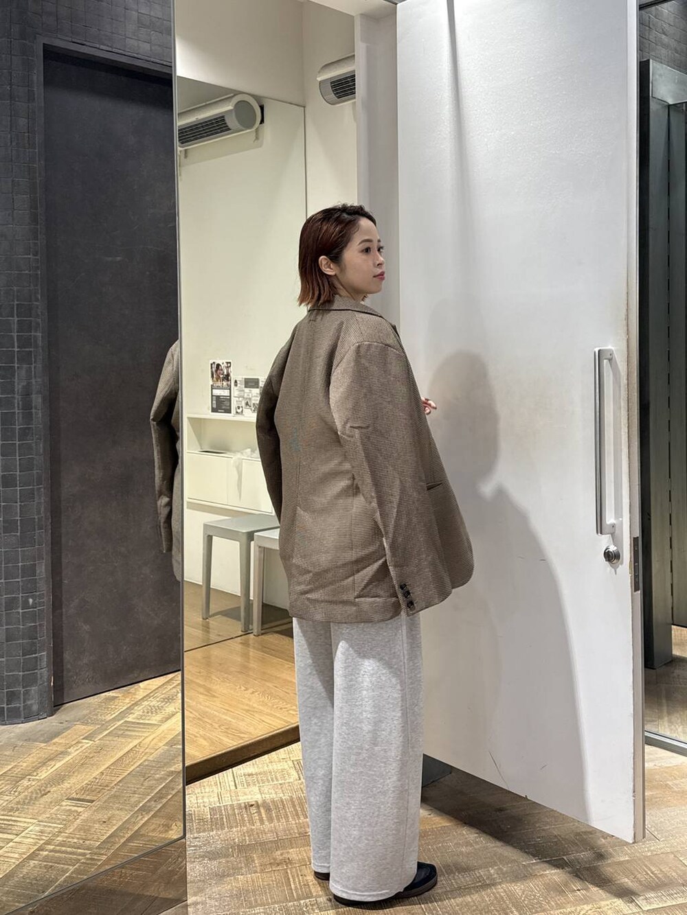 グリーン系のボストンバッグ、グレー系のスウェットパンツ、グレー系のスウェットを着用したレディースの秋コーディネートの2枚目の写真