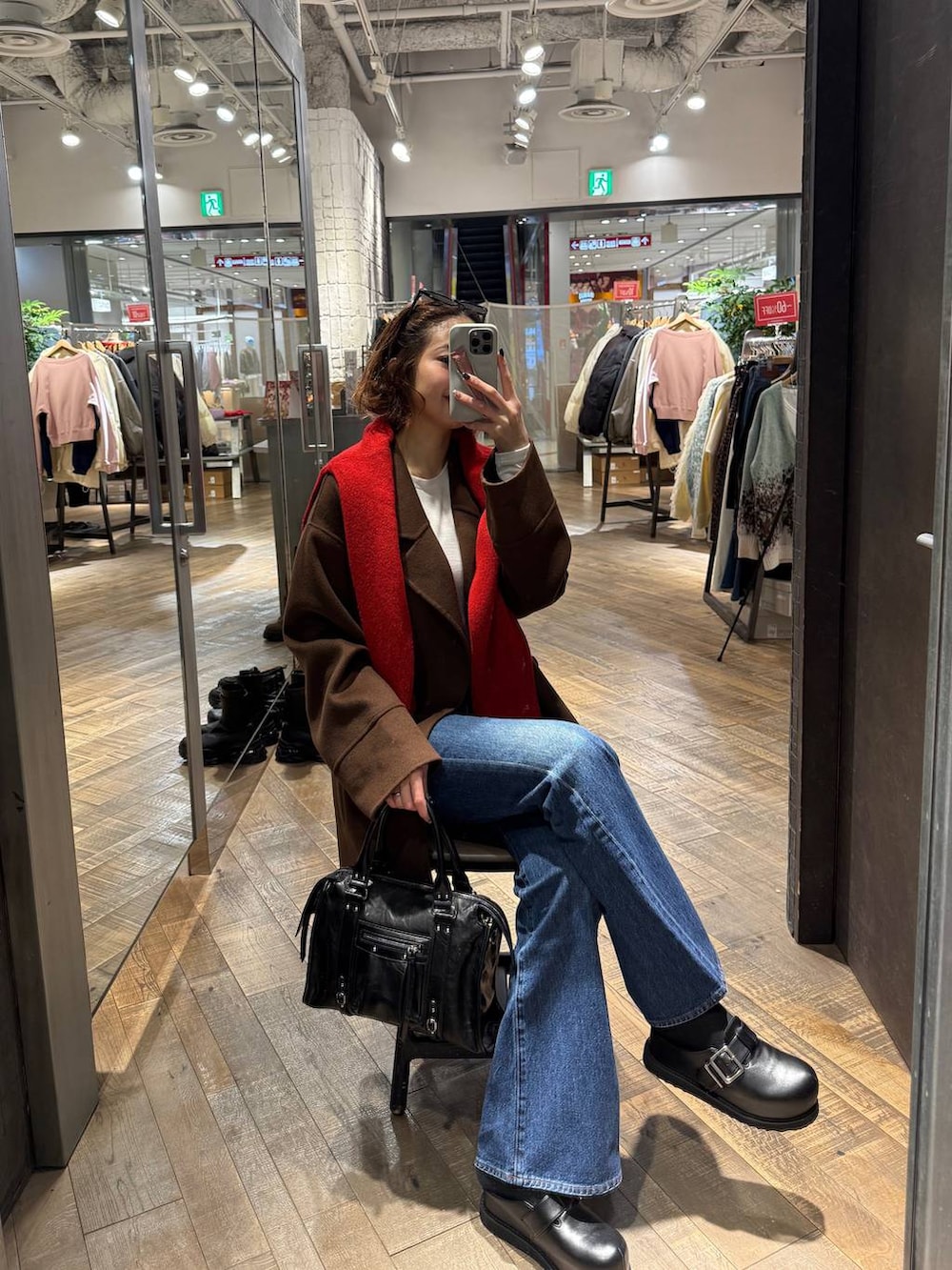 ブラック系のボストンバッグ、ブラウン系のピーコート、ブラック系のその他シューズを着用したレディースの冬コーディネートの2枚目の写真