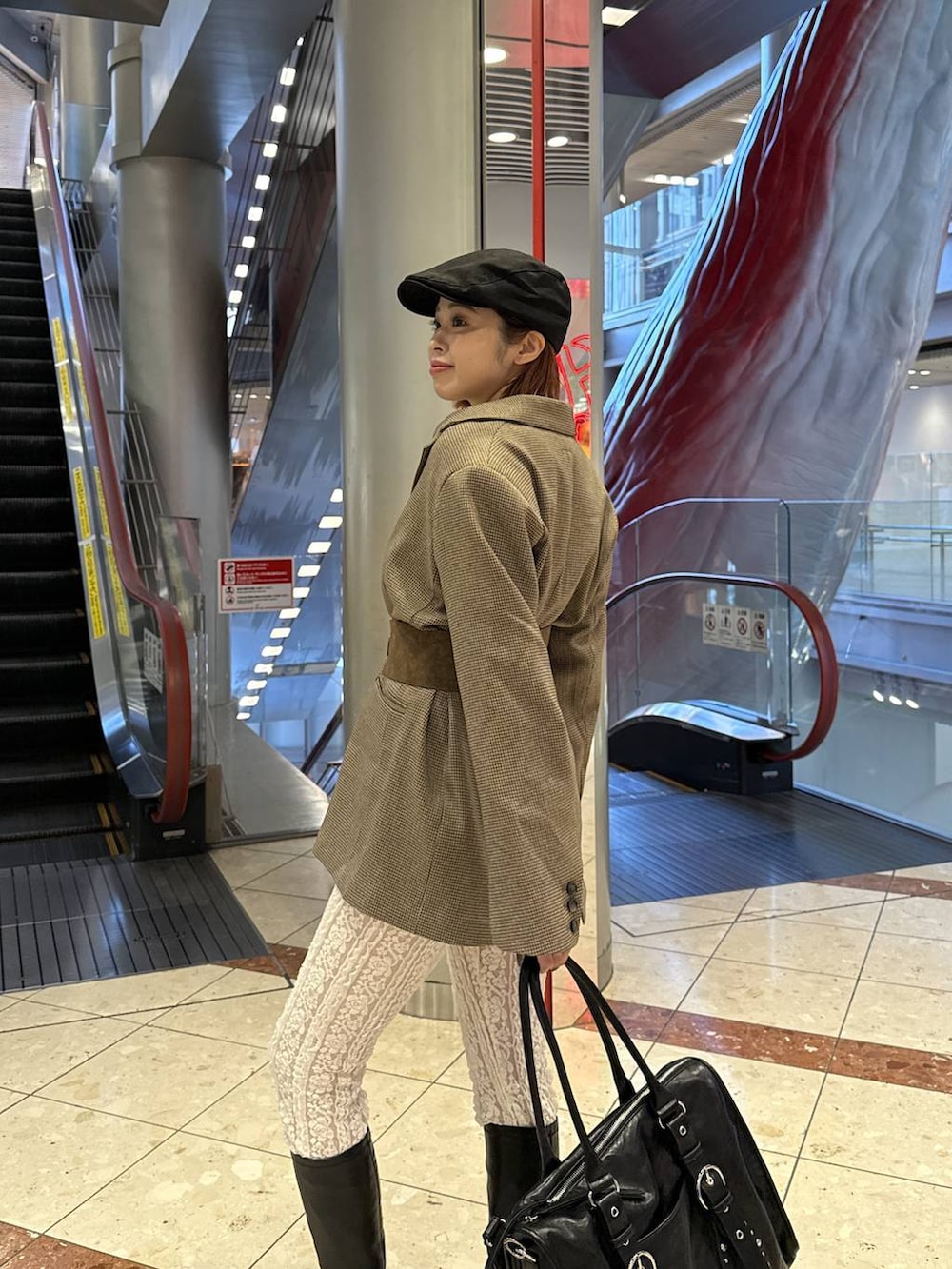 ブラック系のトートバッグ、ブラック系のブーツ、ホワイト系のその他パンツを着用したレディースの秋コーディネートの2枚目の写真