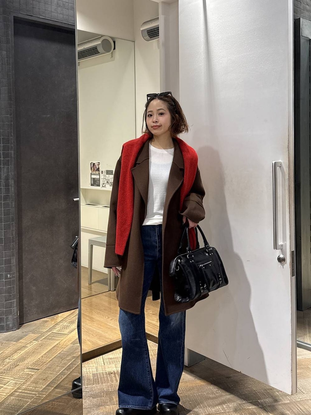 ブラック系のボストンバッグ、ブラウン系のピーコート、ブラック系のその他シューズを着用したレディースの冬コーディネートの3枚目の写真